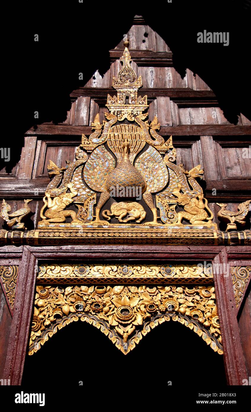 Thailandia: il kong khieu o sopracciglia pelmet e il pavone di legno intagliato sopra l'ingresso principale, Wat Phan Tao, Chiang mai. Wat Phan Tao, fondata nel 1391, forma una sorta di aggiunta al molto più grande Wat Chedi Luang che si trova accanto e immediatamente a sud. Wat Phan Tao significa ‘Tempio di mille fornaci’ o ‘Tempio di mille forni’ e si ritiene che i terreni fossero un tempo il sito di una fonderia, gettando immagini in bronzo del Buddha per il vicino Wat Chedi Luang. Il viharn in legno è uno dei pochi edifici di tempio in legno sopravvissuti a Chiang mai. Foto Stock