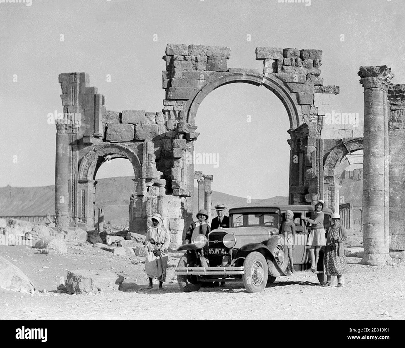 Siria: Turisti europei dalla porta a tre archi a Palmyra (Tadmur), c.. 1900. Palmyra era un'antica città in Siria. Nell'epoca dell'antichità, era un'importante città della Siria centrale, situata in un'oasi a 215 km a nord-est di Damasco e a 180 km a sud-ovest dell'Eufrate a Deir ez-Zor. Era stata a lungo una città carovana vitale per i viaggiatori che attraversavano il deserto siriano ed era conosciuta come la 'sposa del deserto'. La città è anche conosciuta con il suo vecchio nome semitico Tadmor, Tadmur o Tudmur (che significa 'la città che si respinge' in Amorite e 'la città indomita' in Aramaic). Foto Stock