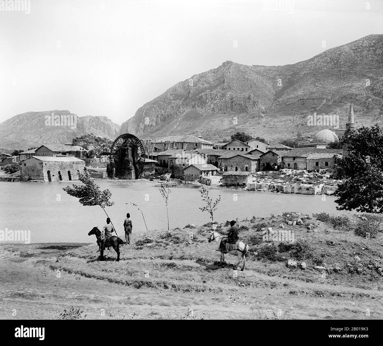 Turchia: Ruota d'acqua gigante (noria) sul fiume Orontes ('Asi') ad Antioch, c. 1898 Antiochia, conosciuta anche come Antiochia sulle Orontes e Antiochia siriana, era una città ellenistica situata vicino all'attuale città di Antakya, sul lato orientale del fiume Orontes. Fu fondata verso la fine del 4th secolo a.C. da Seleuco i Nicator, un generale che servì sotto Alessandro Magno. La sua posizione la vide crescere in influenza e potere, diventando una delle città più importanti dell'Impero Romano, anche se la sua influenza diminuirebbe durante il Medioevo a causa di vari fattori. Foto Stock