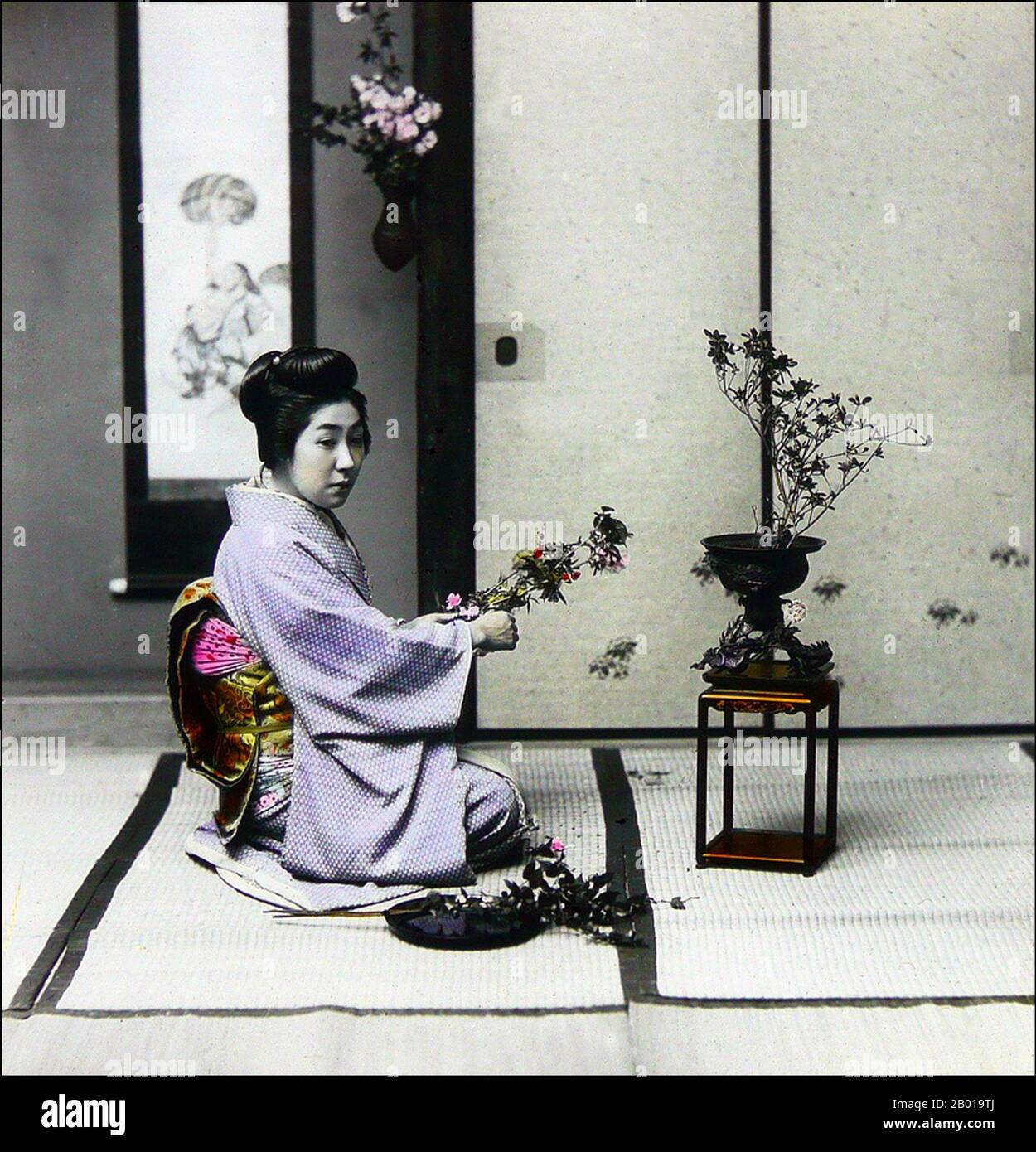 Giappone: Una geisha che arrangiano i fiori. Foto di T. Enami (1859-1929), c.. 1895. T. Enami (Enami Nobukuni) era il nome commerciale di un celebre fotografo del periodo Meiji. Il T. del suo nome commerciale è pensato per essere stato per Toshi, anche se non ha mai scritto fuori su qualsiasi documento personale o di affari. Nato a Edo (ora Tokyo) durante l'era Bakumatsu, Enami fu prima studente di, e poi assistente del noto fotografo e collotipista, Ogawa Kazumasa. Enami si è rilocato a Yokohama, e ha aperto uno studio a Benten-dōri (Benten Street) nel 1892. Foto Stock