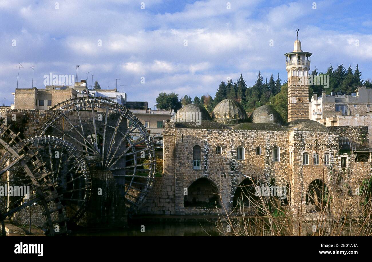 Siria: Una noria del 12th-13th secolo o una gigantesca ruota d'acqua sulle rive del fiume Orontes, Hama. Una noria è una macchina per il sollevamento dell'acqua in un piccolo acquedotto a scopo di irrigazione. Hama è la posizione della città storica di Hamath. Nel 1982 fu teatro del peggiore massacro della storia araba moderna. Il presidente Hafaz al-Assad ordinò al fratello Rifaat al-Assad di sedare una rivolta islamista sunnita nella città. Si stima che tra 25.000 e 30.000 persone siano state massacrate. Foto Stock