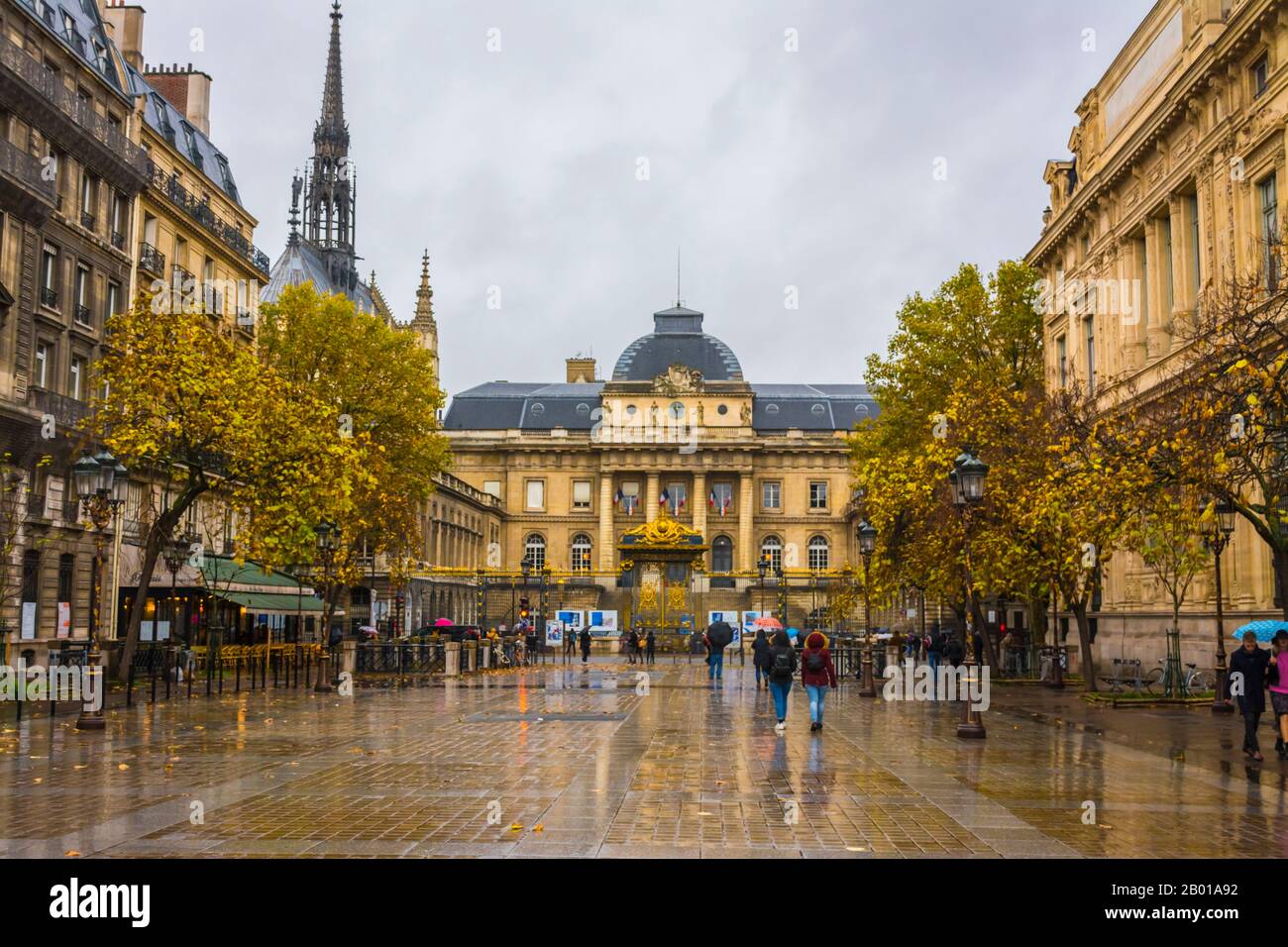 Parigi, Francia - 11 novembre 2019: Palazzo di Giustizia di Parigi da via Lutece e la torre della chiesa Saint Chapel. Persone che camminano sulla strada Foto Stock