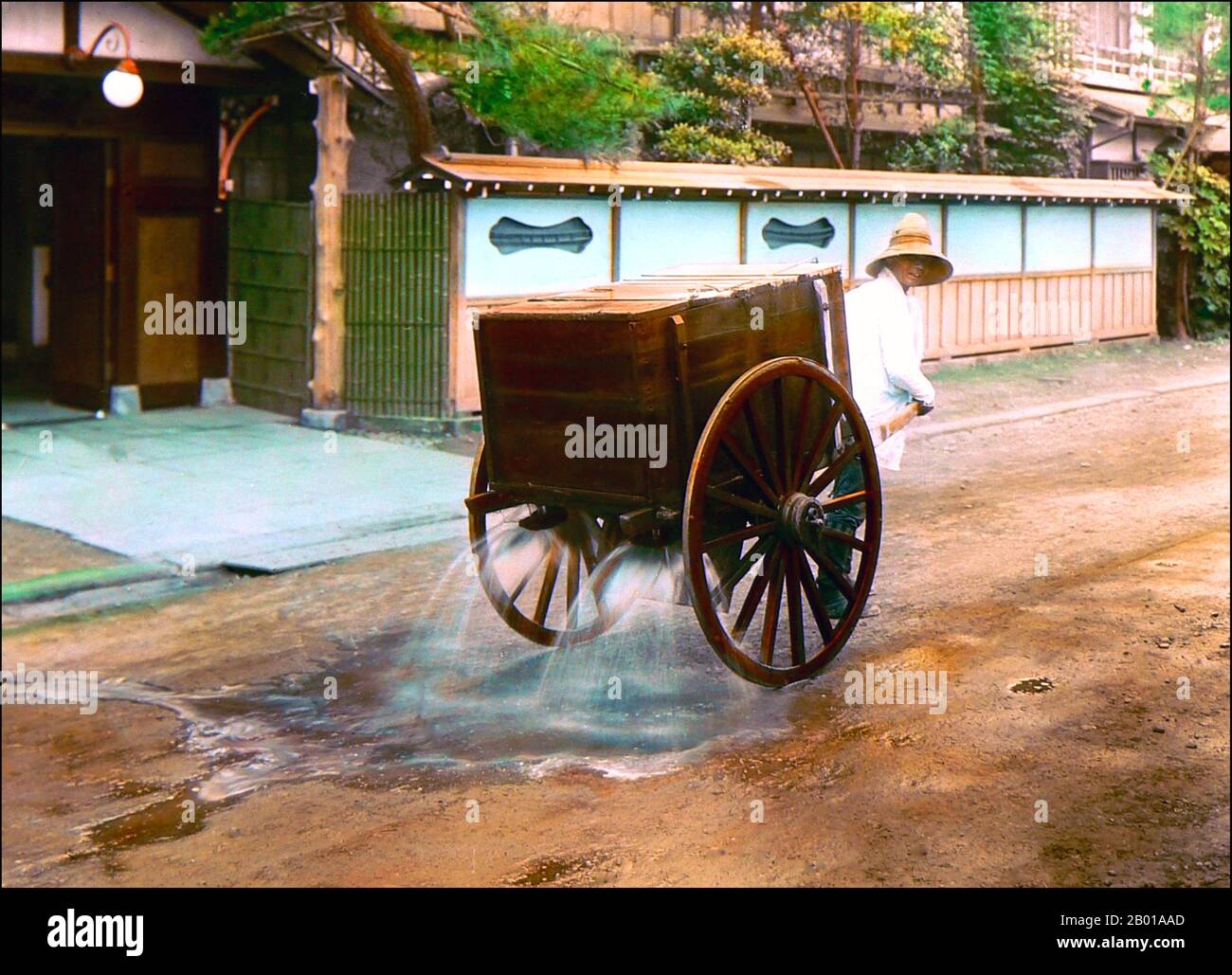 Giappone: La polvere di posa con un carro d'acqua tirato a mano. Foto di T. Enami (1859-1929), c.. 1915. T. Enami (Enami Nobukuni) era il nome commerciale di un celebre fotografo del periodo Meiji. Il T. del suo nome commerciale è pensato per essere stato per Toshi, anche se non ha mai scritto fuori su qualsiasi documento personale o di affari. Nato a Edo (ora Tokyo) durante l'era Bakumatsu, Enami fu prima studente di, e poi assistente del noto fotografo e collotipista, Ogawa Kazumasa. Enami si è rilocato a Yokohama, e ha aperto uno studio a Benten-dōri (Benten Street) nel 1892. Foto Stock