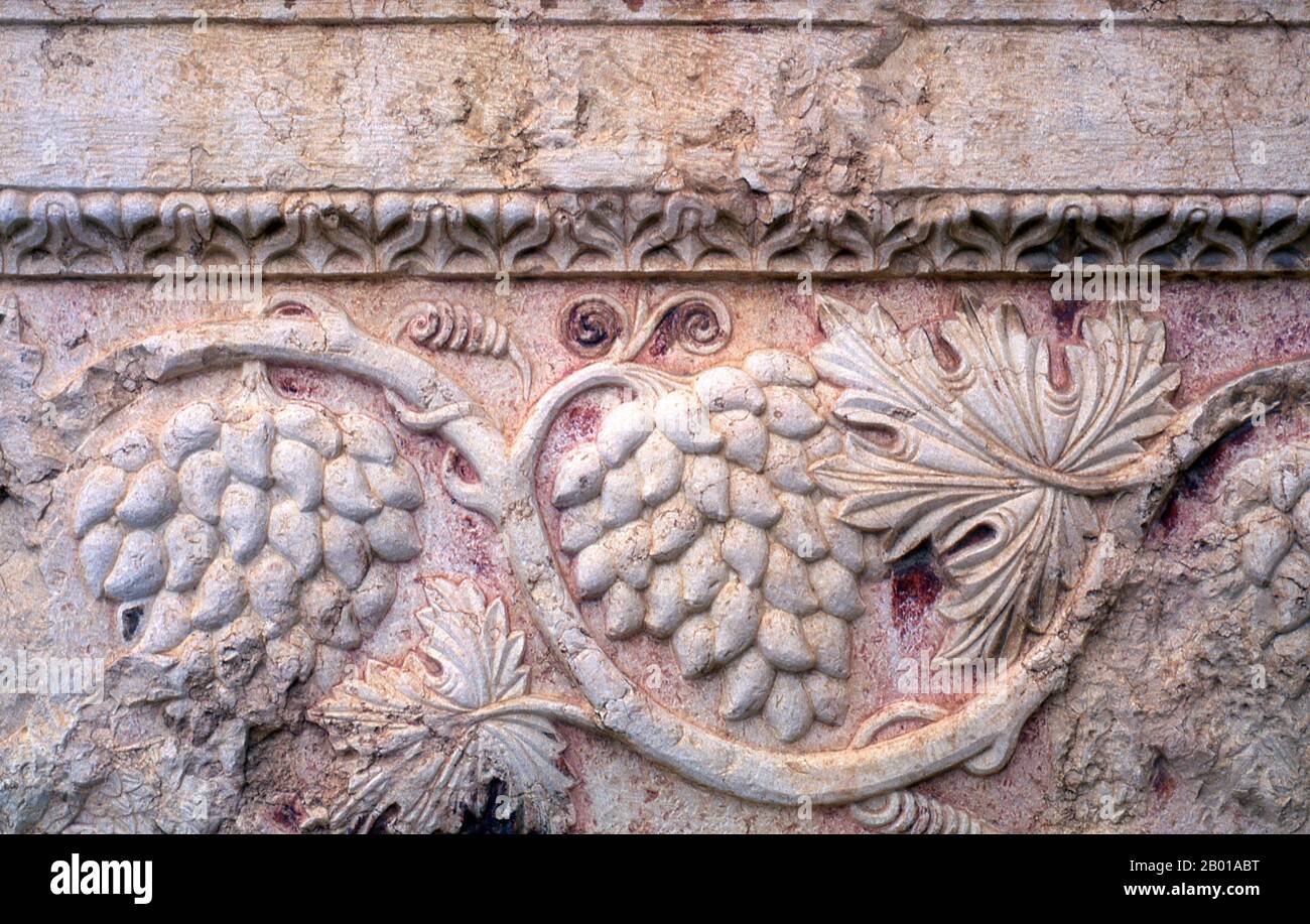 Siria: Uva, rilievo di pietra, Tempio di Bel, Palmyra. Palmyra era un'antica città in Siria. Era una città importante nella Siria centrale, situata in un'oasi 215 km a nord-est di Damasco e 180 km a sud-ovest dell'Eufrate a Deir ez-Zor. Era stata a lungo una città carovana vitale per i viaggiatori che attraversavano il deserto siriano ed era conosciuta come la sposa del deserto. Il primo riferimento documentato alla città con il suo nome semitico Tadmor, Tadmur o Tudmur (che significa 'la città che si respinge' in Amorite e 'la città indomitabile' in Aramaico) è registrato in compresse babilonesi trovati in Mari. Foto Stock