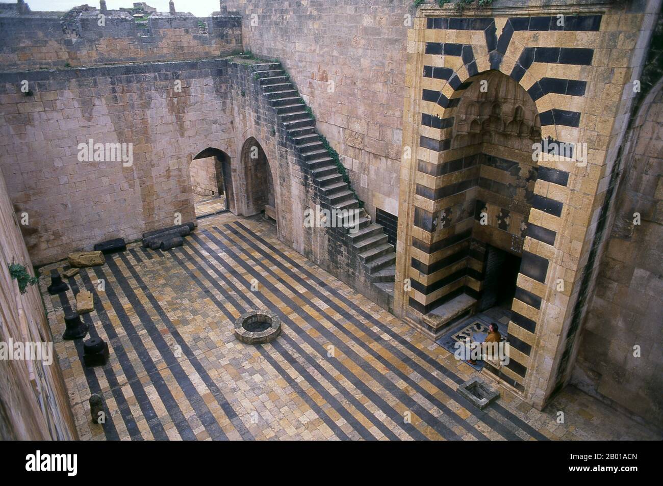 Siria: Cortile all'interno della Cittadella di Aleppo. La Cittadella di Aleppo è un grande palazzo medievale fortificato nel centro della città vecchia di Aleppo, Siria settentrionale. È considerato uno dei castelli più antichi e grandi del mondo. L'uso della collina della Cittadella risale almeno alla metà del 3rd millennio a.C. Successivamente occupata da molte civiltà tra cui i Greci, Bizantini, Ayyubids e Mamelukes, si ritiene che la maggior parte della costruzione così com'è oggi abbia origine dal periodo Ayyubid. Foto Stock
