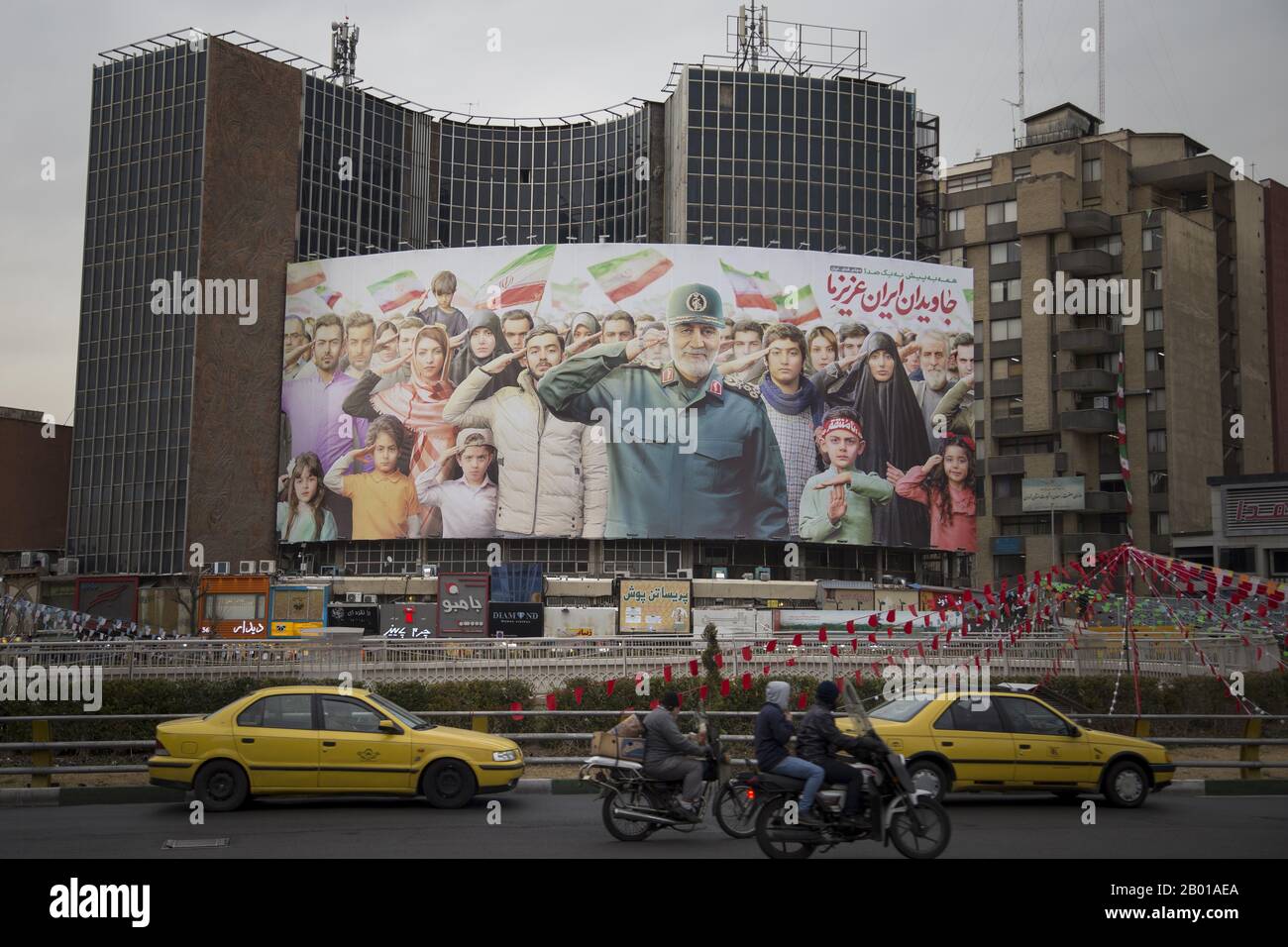 Teheran, IRAN. 17th Feb, 2020. I pedoni camminano oltre un billboard gigante mostra un'immagine di Gen. Qassim Suleimani in Piazza Valiasr a Teheran, Iran. Molti iraniani, martoriati da sanzioni economiche, disordini politici e la persistente minaccia di conflitti militari, dicono di non essere d'umore per votare alle elezioni generali. Parlando di cuori pesanti e di un senso di amarezza, Tehranis si lamenta del fatto che sono stanchi di politici che non sono riusciti a mantenere la parola o a migliorare il tenore di vita. Credito: Rouzbeh Fouladi/Zuma Wire/Alamy Live News Foto Stock