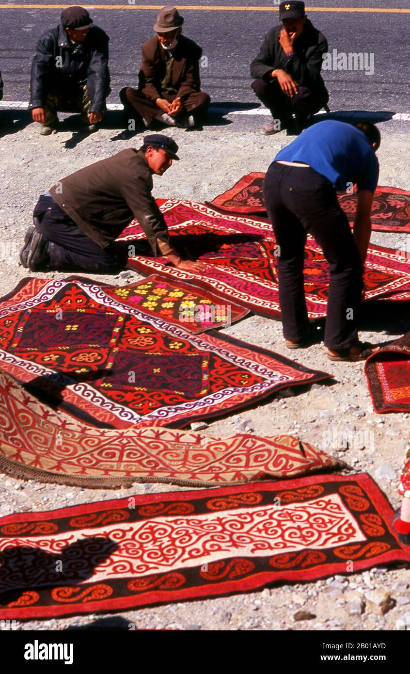 Cina: Commercianti di tappeti di Kirghiz, Karakoram Highway, Xinjiang. Due piccoli insediamenti di nomadi Kirghiz (Kirghiz o Kirghiz) si trovano sul lato del lago Karakul in alto nelle montagne di Pamir. I visitatori possono pernottare in una delle loro case mobili o yurts – Kirghiz uomini si avvicineranno i viaggiatori come arrivare al lago e si offrono di organizzare questo alloggio. Il Kirghizistan è uno dei 56 gruppi etnici ufficialmente riconosciuti dalla Repubblica popolare cinese. In Cina ci sono più di 145.000 Kirghizistan. La Zhongba Gonglu o Karakoram Highway è una meraviglia ingegneristica che è stata aperta nel 1986. Foto Stock