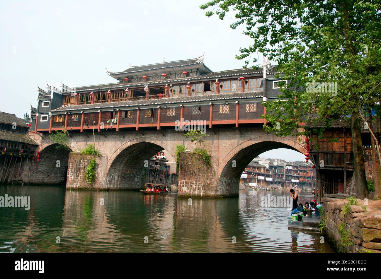 Cina: Ponte di Hong Qiao, famoso ponte coperto di Fenghuang. Fenghuang è cinese per Phoenix e si riferisce al mitico uccello da fuoco sacro che si può trovare nelle mitologie dei Persiani, Greci, Romani, Egiziani, Cinesi, E (secondo Sanchuniathon) i Fenici. La leggenda suggerisce che due phoenixes sulla scoperta della città hovered sopra per un certo tempo considerevole prima di volare riluttante via. Fenghuang è un'antica città ben conservata che risale al 248 a.C. Ospita le minoranze Miao e Tujia. Foto Stock