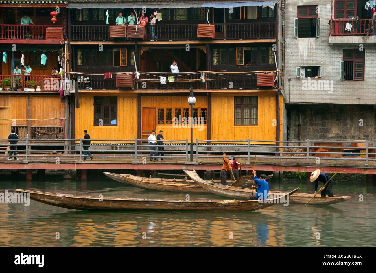 Cina: Barcaioli di mattina presto sul fiume Tuo, Fenghuang, provincia di Hunan. Fenghuang è cinese per Phoenix e si riferisce al mitico uccello da fuoco sacro che si può trovare nelle mitologie dei Persiani, Greci, Romani, Egiziani, Cinesi, E (secondo Sanchuniathon) i Fenici. La leggenda suggerisce che due phoenixes sulla scoperta della città hovered sopra per un certo tempo considerevole prima di volare riluttante via. Fenghuang è un'antica città ben conservata che risale al 248 a.C. Ospita le minoranze Miao e Tujia. Foto Stock