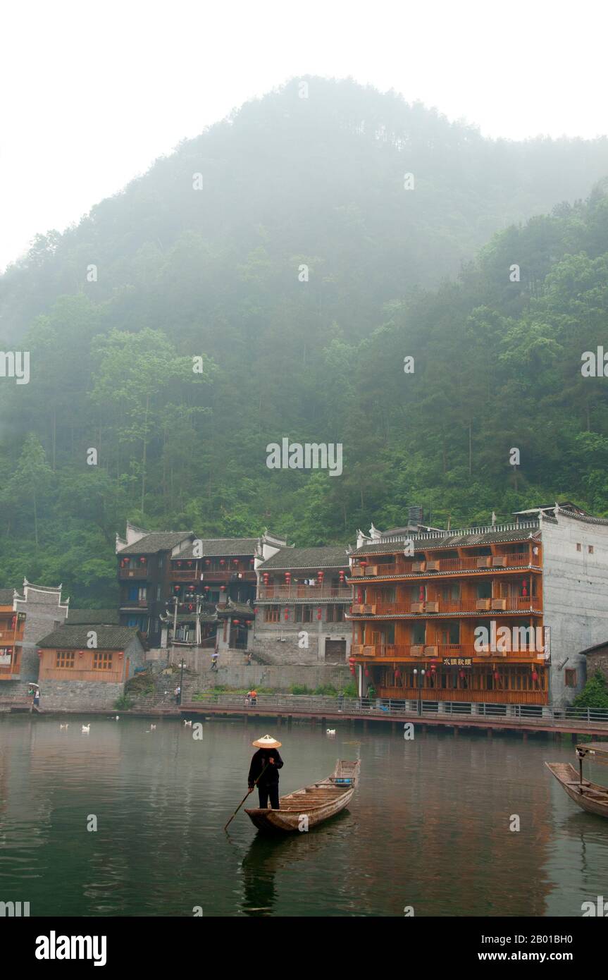 Cina: Barcaiolo di mattina presto sul fiume Tuo, Fenghuang, provincia di Hunan. Fenghuang è cinese per Phoenix e si riferisce al mitico uccello da fuoco sacro che si può trovare nelle mitologie dei Persiani, Greci, Romani, Egiziani, Cinesi, E (secondo Sanchuniathon) i Fenici. La leggenda suggerisce che due phoenixes sulla scoperta della città hovered sopra per un certo tempo considerevole prima di volare riluttante via. Fenghuang è un'antica città ben conservata che risale al 248 a.C. Ospita le minoranze Miao e Tujia. Foto Stock