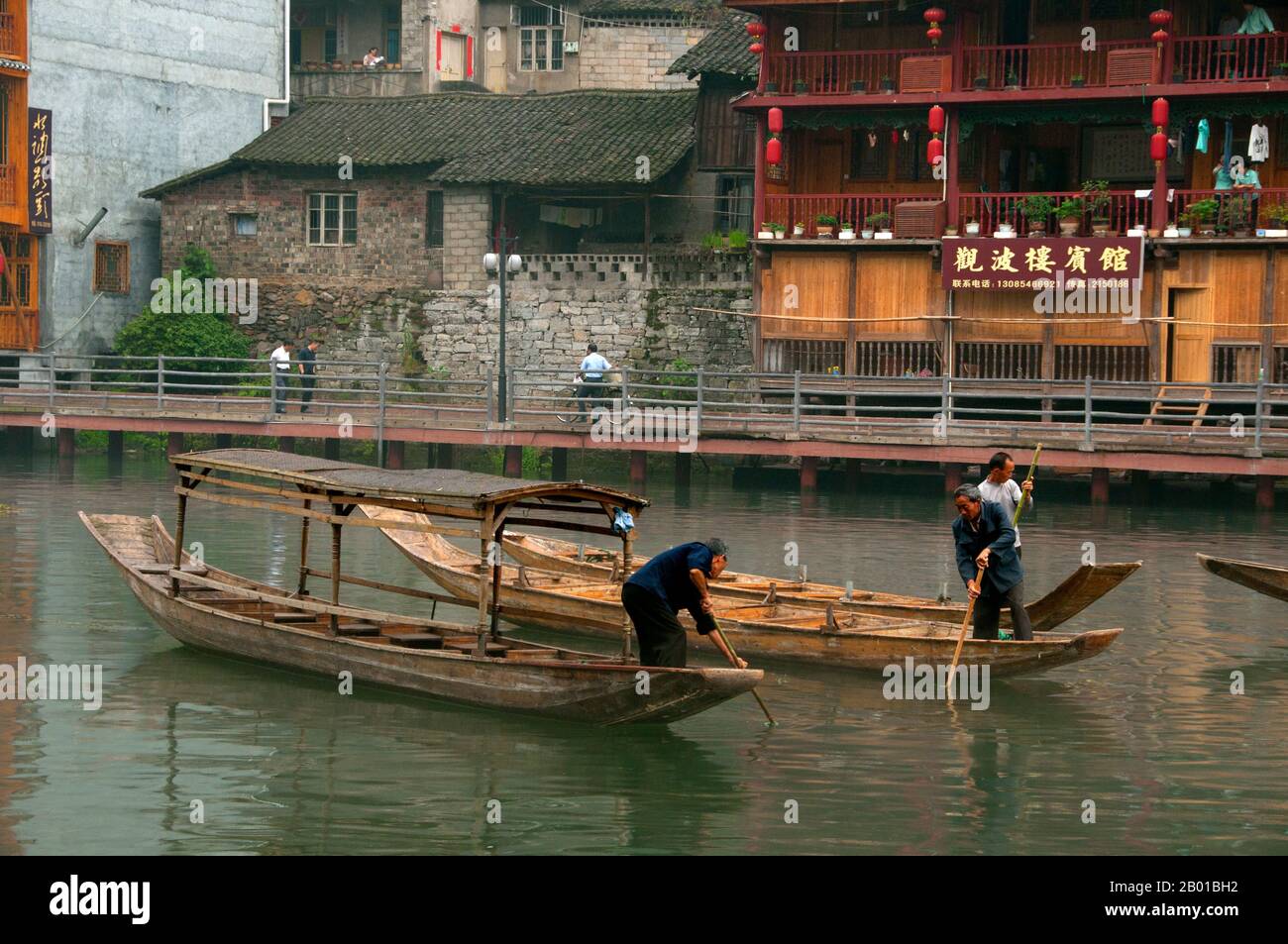 Cina: Barcaioli di mattina presto sul fiume Tuo, Fenghuang, provincia di Hunan. Fenghuang è cinese per Phoenix e si riferisce al mitico uccello da fuoco sacro che si può trovare nelle mitologie dei Persiani, Greci, Romani, Egiziani, Cinesi, E (secondo Sanchuniathon) i Fenici. La leggenda suggerisce che due phoenixes sulla scoperta della città hovered sopra per un certo tempo considerevole prima di volare riluttante via. Fenghuang è un'antica città ben conservata che risale al 248 a.C. Ospita le minoranze Miao e Tujia. Foto Stock