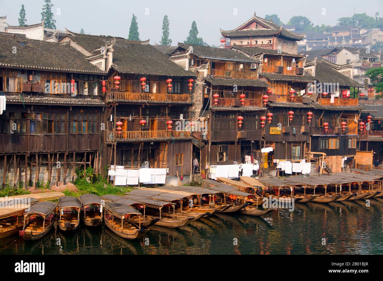 Cina: Vecchie case di legno lungo le rive del fiume Tuo, Fenghuang, provincia di Hunan. Fenghuang è cinese per Phoenix e si riferisce al mitico uccello da fuoco sacro che si può trovare nelle mitologie dei Persiani, Greci, Romani, Egiziani, Cinesi, E (secondo Sanchuniathon) i Fenici. La leggenda suggerisce che due phoenixes sulla scoperta della città hovered sopra per un certo tempo considerevole prima di volare riluttante via. Fenghuang è un'antica città ben conservata che risale al 248 a.C. Ospita le minoranze Miao e Tujia. Foto Stock