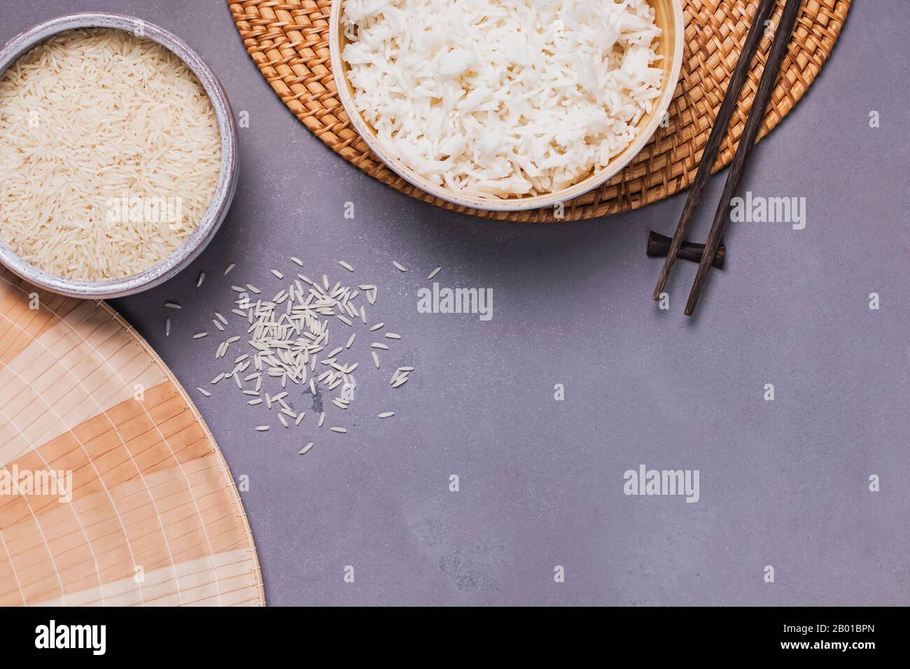 Ciotole con riso bianco crudo e cotto a grani lunghi Foto Stock