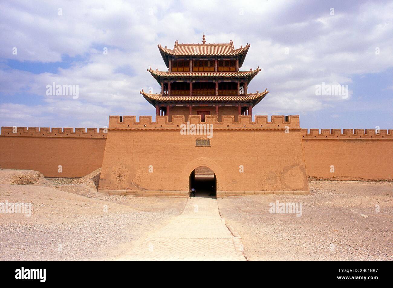 Cina: Porta occidentale e torre a Jiayuguan Fort, provincia di Gansu. Jiayuguan, il “primo e più grande passo sotto il cielo”, fu completato nel 1372 su ordine di Zhu Yuanzhang, il primo imperatore Ming (1368-98), per segnare la fine della Grande Muraglia Ming. Era anche il limite stesso della civiltà cinese, e gli inizi delle terre “barbariche” esterne. Per secoli il forte non era solo di importanza strategica per i cinesi Han, ma anche di significato culturale. Questo era l'ultimo luogo civilizzato prima delle tenebre esterne, e quelli che procedono oltre affrontarono una vita di esilio. Foto Stock