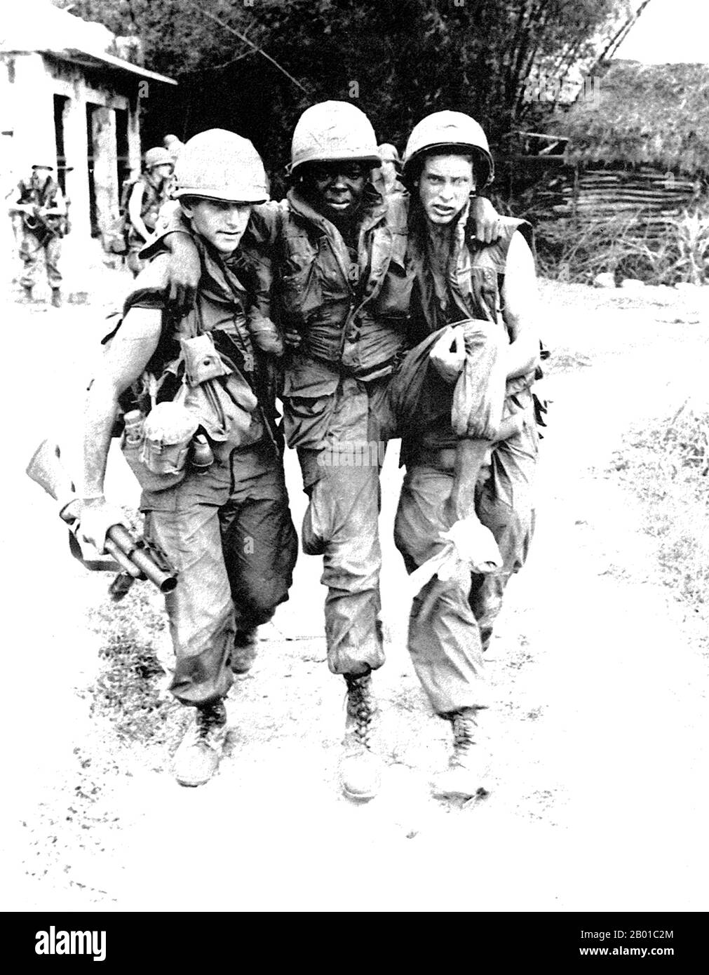 Vietnam: Due soldati dell'esercito americano che aiutano un compagno ferito a My Lai. Foto di Ronald L. Haeberle (pubblico dominio), marzo 6 1968. Soldati STATUNITENSI coinvolti nel massacro di My Lai o Thảm sát Mỹ Lai (6 marzo 1868) nel Vietnam centrale, quando da 347 a 504 civili vietnamiti disarmati sono stati massacrati da un'unità di forze statunitensi sotto il comando del secondo tenente William Calley. Foto Stock