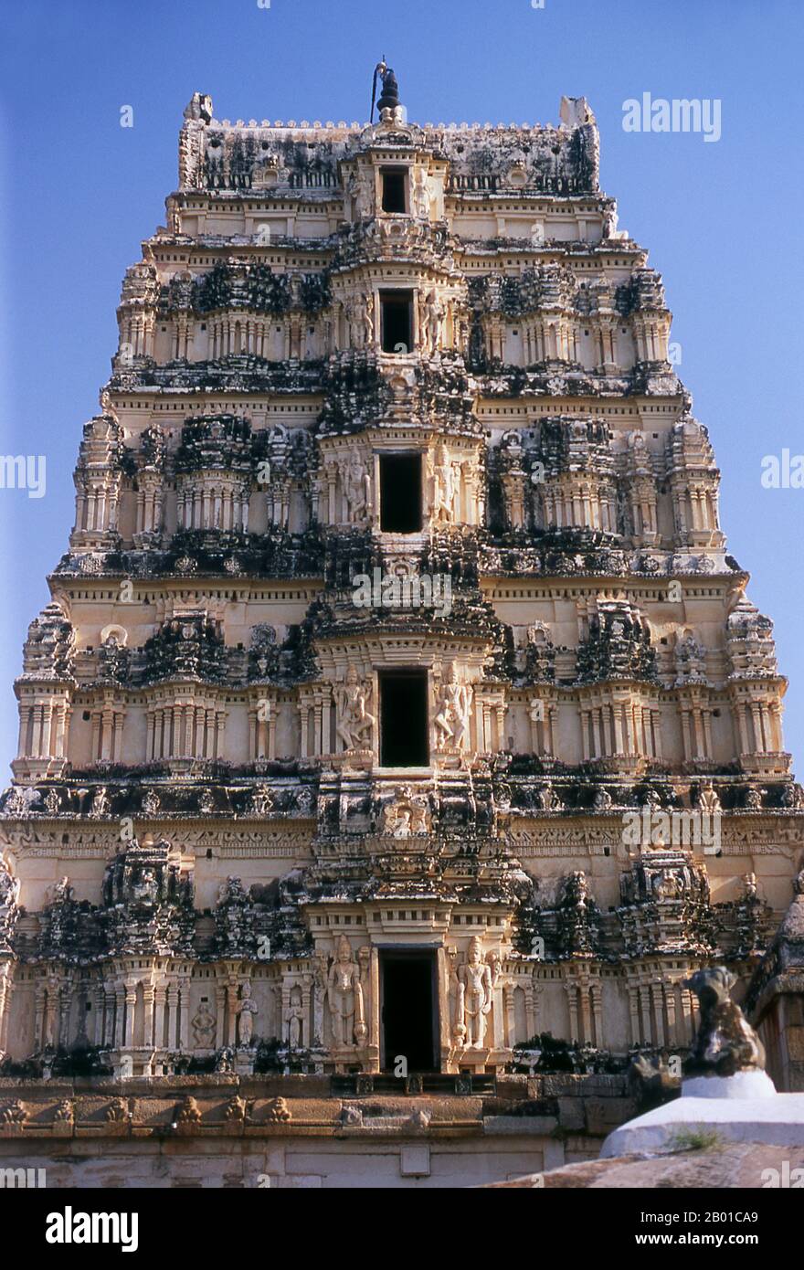 India: La torre settentrionale (gopuram), tempio di Virupaksha, Hampi, stato di Karnataka. Il Tempio di Virupaksha (conosciuto anche come Tempio di Pampapathi) è il principale centro di pellegrinaggio di Hampi. E' completamente intatto tra le rovine circostanti ed è ancora utilizzato nel culto. Il tempio è dedicato al Signore Shiva, qui conosciuto come Virupaksha, come la consorte della dea locale Pampa, associata al fiume Tungabhadra. Hampi è un villaggio nel nord dello stato di Karnataka. Si trova all'interno delle rovine di Vijayanagara, l'ex capitale dell'Impero Vijayanagara. Foto Stock