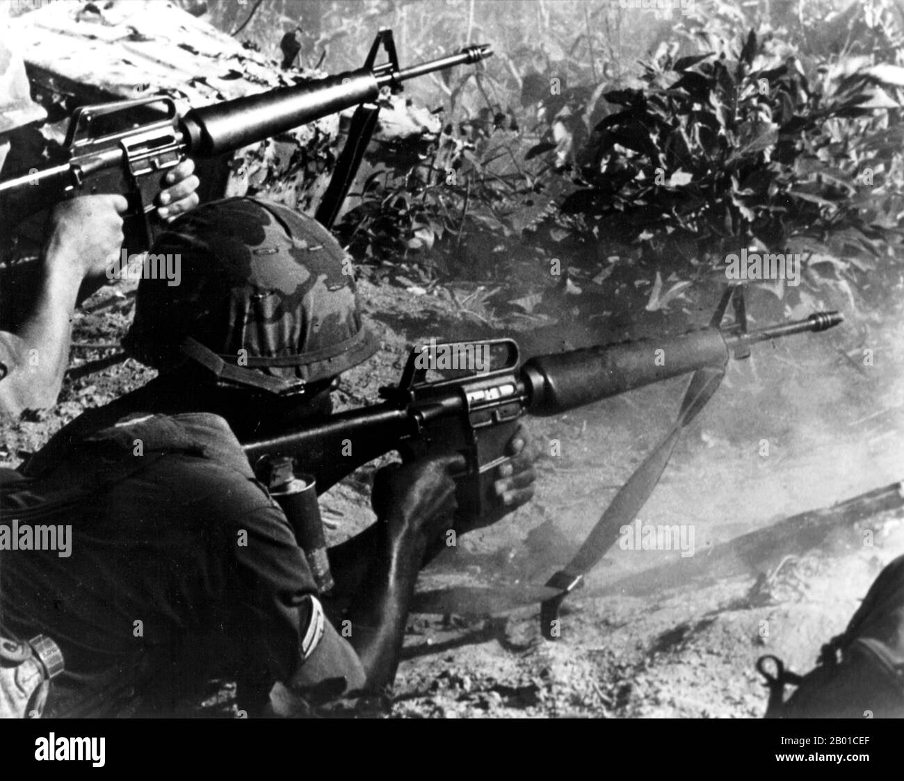 Vietnam: Un sergente e un rifleman americano ingaggiare guerriglieri National Liberation Front (NLF, Viet Cong) con M16 fucili, c.. 1967-1973. La seconda guerra indochina, conosciuta in America come la guerra del Vietnam, fu un conflitto militare dell'epoca della guerra fredda che si verificò in Vietnam, Laos e Cambogia dal 1 novembre 1955 alla caduta di Saigon il 30 aprile 1975. Questa guerra seguì la prima Guerra d'Indocina e fu combattuta tra il Vietnam del Nord, sostenuto dai suoi alleati comunisti, e il governo del Vietnam del Sud, sostenuto dagli Stati Uniti e da altre nazioni anticomuniste. Foto Stock