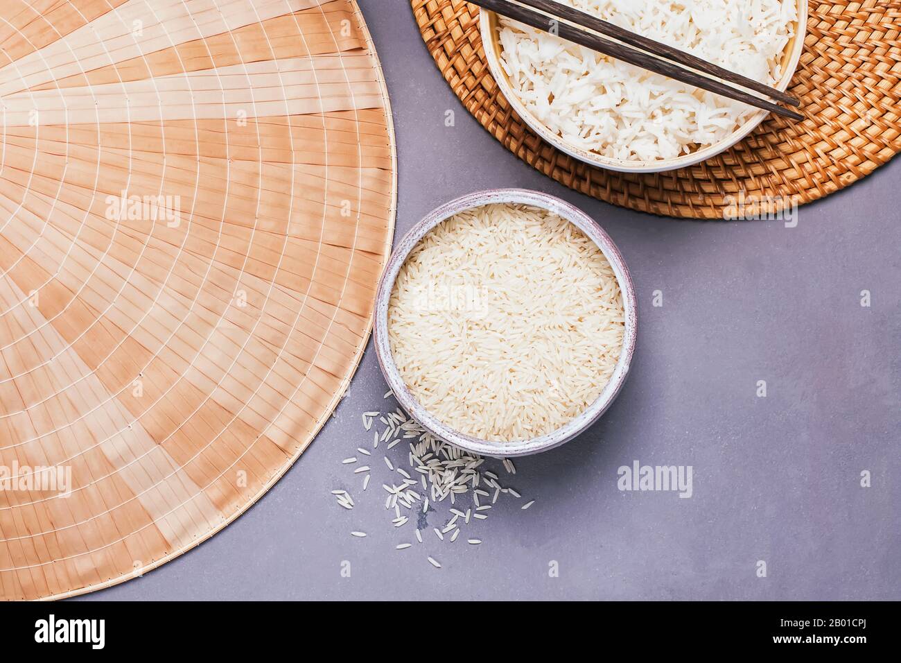 Ciotole con riso bianco crudo e cotto a grani lunghi Foto Stock