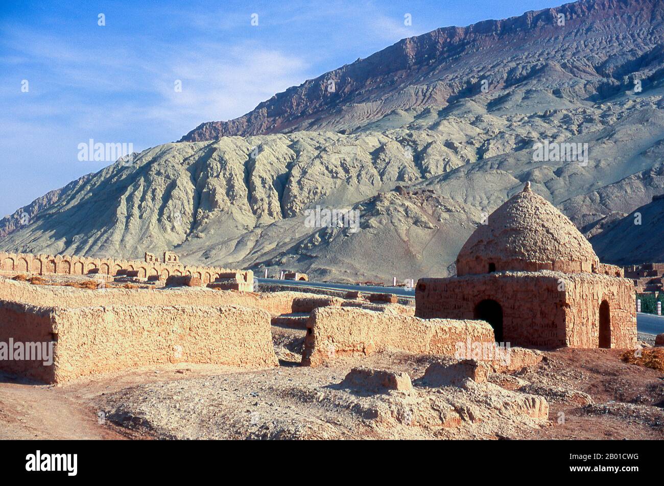 Cina: Un cimitero vicino al villaggio di Tuyoq vicino a Turpan, provincia di Xinjiang. Tuyoq o Tuyugou è un antico villaggio-oasi nel deserto di Taklamakan, 70 km a est di Turpan in una valle lussureggiante che si estende nelle Flaming Mountains, con un ben conservato orientamento Uyghur. E' famosa per le sue uve senza semi e per un certo numero di antiche grotte di meditazione buddista nelle vicinanze che contengono affreschi, la più conosciuta essendo le grotte di Bezeklik Thousand Buddha. Foto Stock