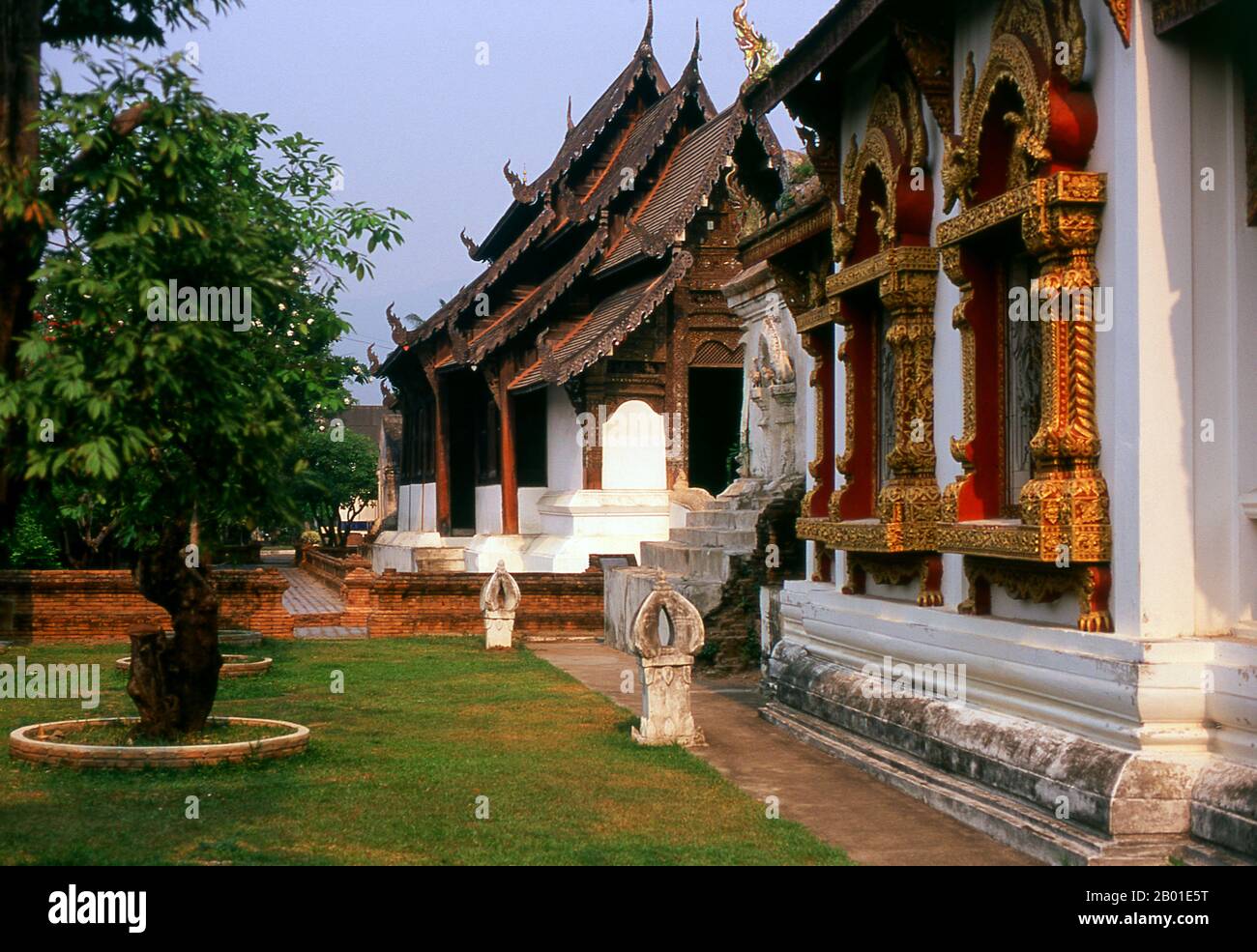 Thailandia: Ubosot (sala di ordinazione) in primo piano con il viharn sullo sfondo, Wat Prasat, Chiang mai. Wat Prasat (วัดปราสาท) risale almeno al 16th° secolo, ed è probabilmente ancora più vecchio. L'edificio più importante del complesso del tempio è l'antico viharn, che risale al 1823 ma è stato ristrutturato con gusto nel 1987. Costruito nel tradizionale e distintivo stile LAN Na, il viharn e' costruito con pannelli di legno di teak abilmente lavorati su una base di mattoni e stucco imbiancati. Foto Stock