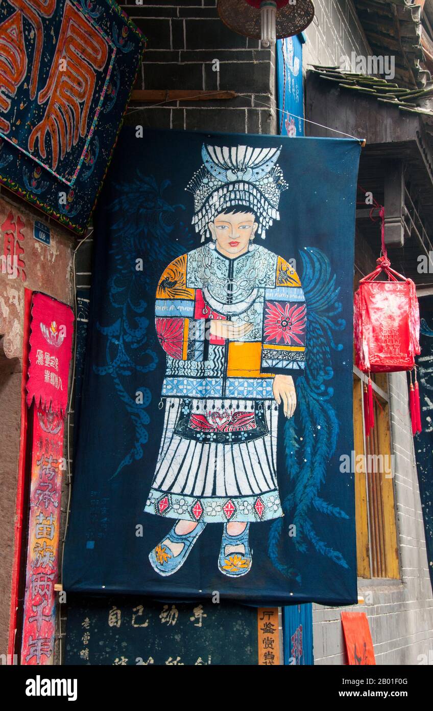 Cina: Bandiera Miao fuori un negozio di vendita di abbigliamento Miao e manufatti, Fenghuang, provincia di Hunan. Fenghuang è cinese per Phoenix e si riferisce al mitico uccello da fuoco sacro che si può trovare nelle mitologie dei Persiani, Greci, Romani, Egiziani, Cinesi, E (secondo Sanchuniathon) i Fenici. La leggenda suggerisce che due phoenixes sulla scoperta della città hovered sopra per un certo tempo considerevole prima di volare riluttante via. Fenghuang è un'antica città ben conservata che risale al 248 a.C. Ospita le minoranze Miao e Tujia. Foto Stock