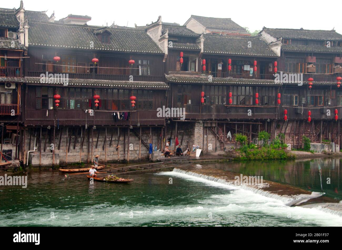 Cina: Vecchie case di legno lungo le rive del fiume Tuo, Fenghuang, provincia di Hunan. Fenghuang è cinese per Phoenix e si riferisce al mitico uccello da fuoco sacro che si può trovare nelle mitologie dei Persiani, Greci, Romani, Egiziani, Cinesi, E (secondo Sanchuniathon) i Fenici. La leggenda suggerisce che due phoenixes sulla scoperta della città hovered sopra per un certo tempo considerevole prima di volare riluttante via. Fenghuang è un'antica città ben conservata che risale al 248 a.C. Ospita le minoranze Miao e Tujia. Foto Stock