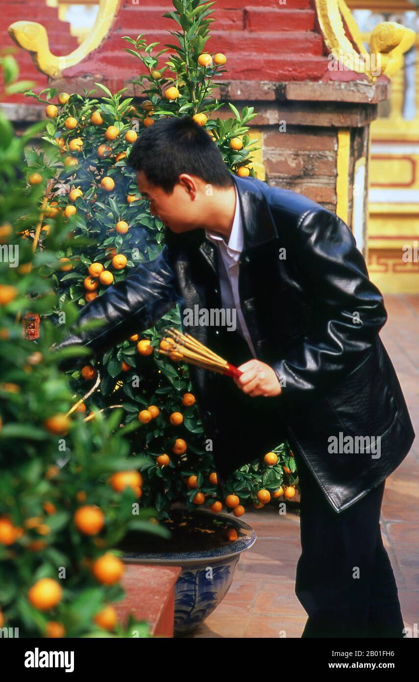 Vietnam: Tet (Capodanno vietnamita) celebranti a Tran Quoc Pagoda, ho Tay (Lago Ovest), Hanoi. Il tempio più antico di Hanoi, Chua Tran Quoc, si trova su una piccola isola appena ad ovest della strada sopraelevata di ho Tay. Le origini precise della pagoda sono sconosciute, ma secondo la leggenda fu originariamente fondata dalle rive del Fiume Rosso durante il regno di Re Ly Nam De (544-548) in un breve interregno durante il millennio dell’occupazione cinese. La più grande festa nazionale del Vietnam è Tet – più propriamente, Tet Nguyen Dan, “Festival del primo giorno” – in coincidenza con il primo giorno del capodanno lunare. Foto Stock