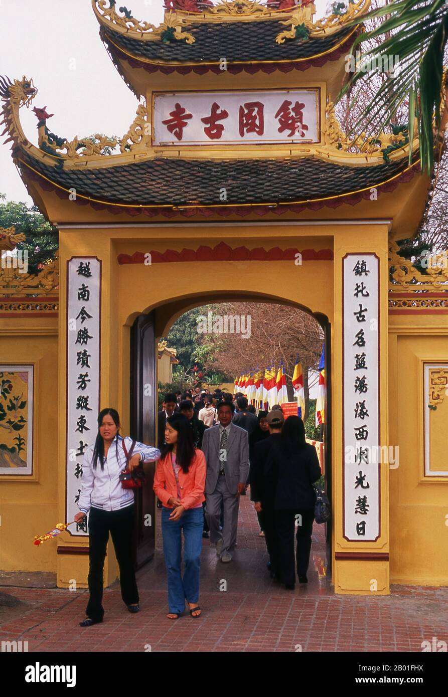 Vietnam: Tet (Capodanno vietnamita) celebranti all'ingresso della Pagoda Tran Quoc, ho Tay, Hanoi. Il tempio più antico di Hanoi, Chua Tran Quoc, si trova su una piccola isola appena ad ovest della strada sopraelevata di ho Tay (Lago Ovest). Le origini precise della pagoda sono sconosciute, ma secondo la leggenda fu originariamente fondata dalle rive del Fiume Rosso durante il regno di Re Ly Nam De (544-548) in un breve interregno durante il millennio dell’occupazione cinese. La più grande festa nazionale del Vietnam è Tet – più propriamente, Tet Nguyen Dan, “Festival del primo giorno” – in coincidenza con il primo giorno del nuovo anno. Foto Stock