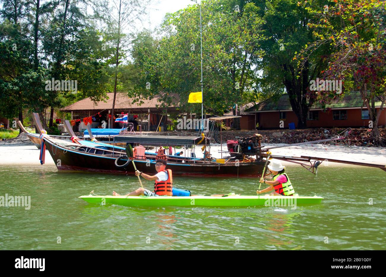 Thailandia: Kayak, Ao Pante Malaka, Ko Tarutao, Ko Tarutao Marine National Park. Ao Pante Melaka è una lunga baia sulla riva nord-occidentale di Ko Tarutao, con una spiaggia di sabbia fine. Qui si trovano la sede centrale del Parco Nazionale Marino di Ko Tarutao e un centro di servizi turistici che ospita una mostra che copre lo sfondo storico e naturale del parco. Il Parco Nazionale Marino di Ko Tarutao consiste di 51 isole in due gruppi principali sparsi attraverso il Mare delle Andamane nella Thailandia più meridionale. Solo sette delle isole sono di qualsiasi dimensione, tra cui Ko Tarutao a est. Foto Stock