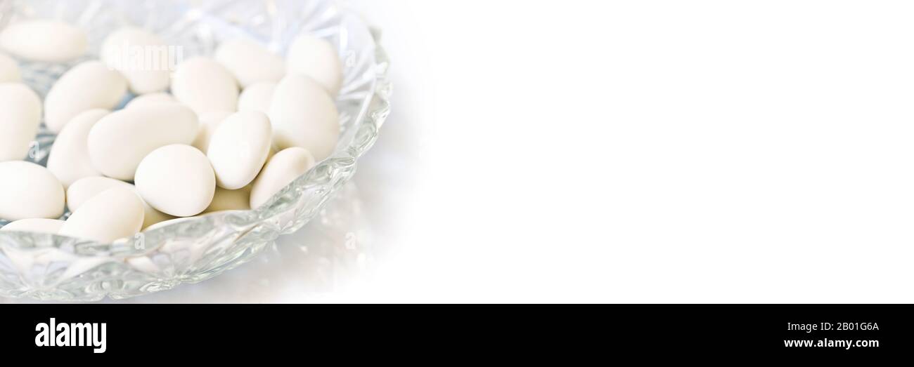Draghi bianchi in un piatto per il battesimo o il matrimonio su sfondo bianco panoramico Foto Stock