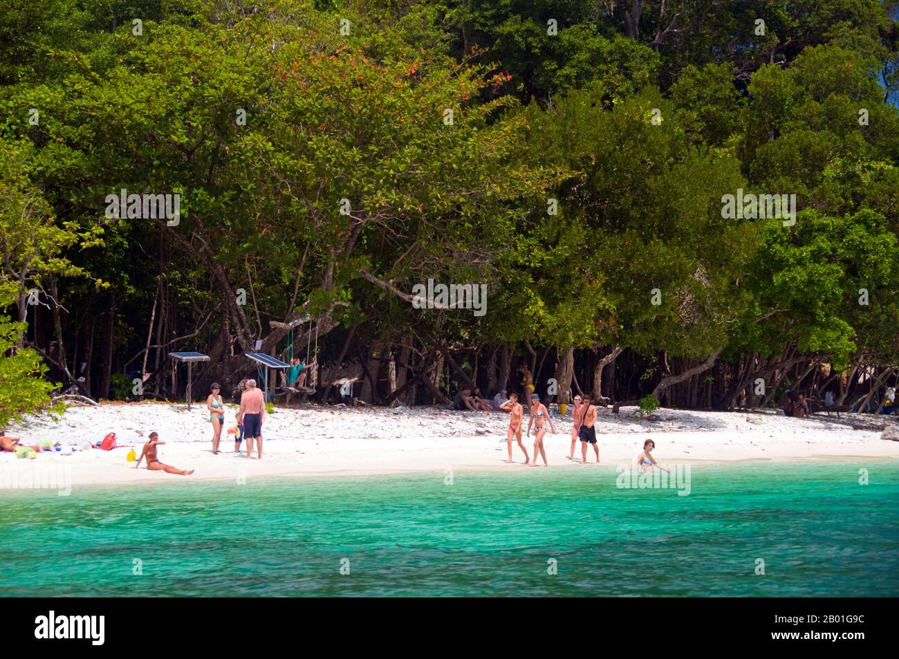 Thailandia: Un gruppo di tour si rilassa sulla spiaggia di Ko Rawi, Ko Tarutao Marine National Park. Ko Rawi è la seconda isola più grande del gruppo Adang-Rawi che fa parte a sua volta del Parco Nazionale Marino di Ko Tarutao. Ha una superficie di circa 29 kmq (11,5 kmq) e si trova a soli 10km km (6 miglia) ad ovest di Ko Adang. Il Parco Nazionale Marino di Ko Tarutao consiste di 51 isole in due gruppi principali sparsi attraverso il Mare delle Andamane nella Thailandia più meridionale. Solo sette delle isole sono di qualsiasi dimensione, tra cui Ko Tarutao a est, e Ko Adang-Ko Rawi a ovest. Foto Stock