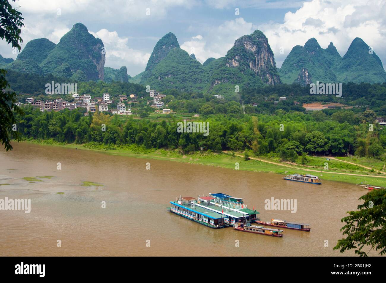Cina: Barche sul fiume li a Yangshuo, vicino a Guilin, provincia del Guangxi. Yangshuo è giustamente famosa per i suoi paesaggi suggestivi. Si trova sulla riva occidentale del fiume li (Lijiang) ed è a soli 60 km a valle di Guilin. Negli ultimi anni è diventata una destinazione popolare tra i turisti pur mantenendo la sua atmosfera di piccola città fluviale. Guilin è la scena dei paesaggi più famosi della Cina, ispirando migliaia di dipinti nel corso di molti secoli. Le "montagne e fiumi più belli sotto il cielo" sono così stimolanti che poeti, artisti e turisti hanno reso questa attrazione naturale numero uno della Cina. Foto Stock