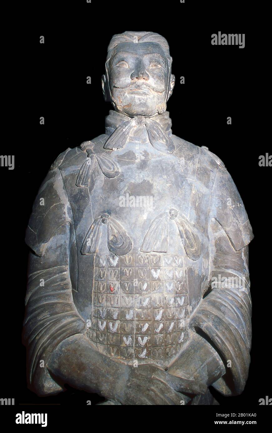 Cina: Un guerriero dell'esercito di terracotta a guardia della tomba di Qin Shi Huang, primo imperatore di una Cina unificata (246-221 a.C.), vicino a Xi'an. Durante una siccità nel 1974, gli agricoltori scavavano un pozzo in uno dei reperti archeologici più incredibili della storia moderna: I guerrieri di terracotta. L'esercito di terracotta, migliaia di soldati, cavalli e carri, era rimasto segretamente in servizio per circa 2.000 anni, a guardia del vicino mausoleo di Qin Shu Huang, il primo imperatore di una Cina unificata. Foto Stock