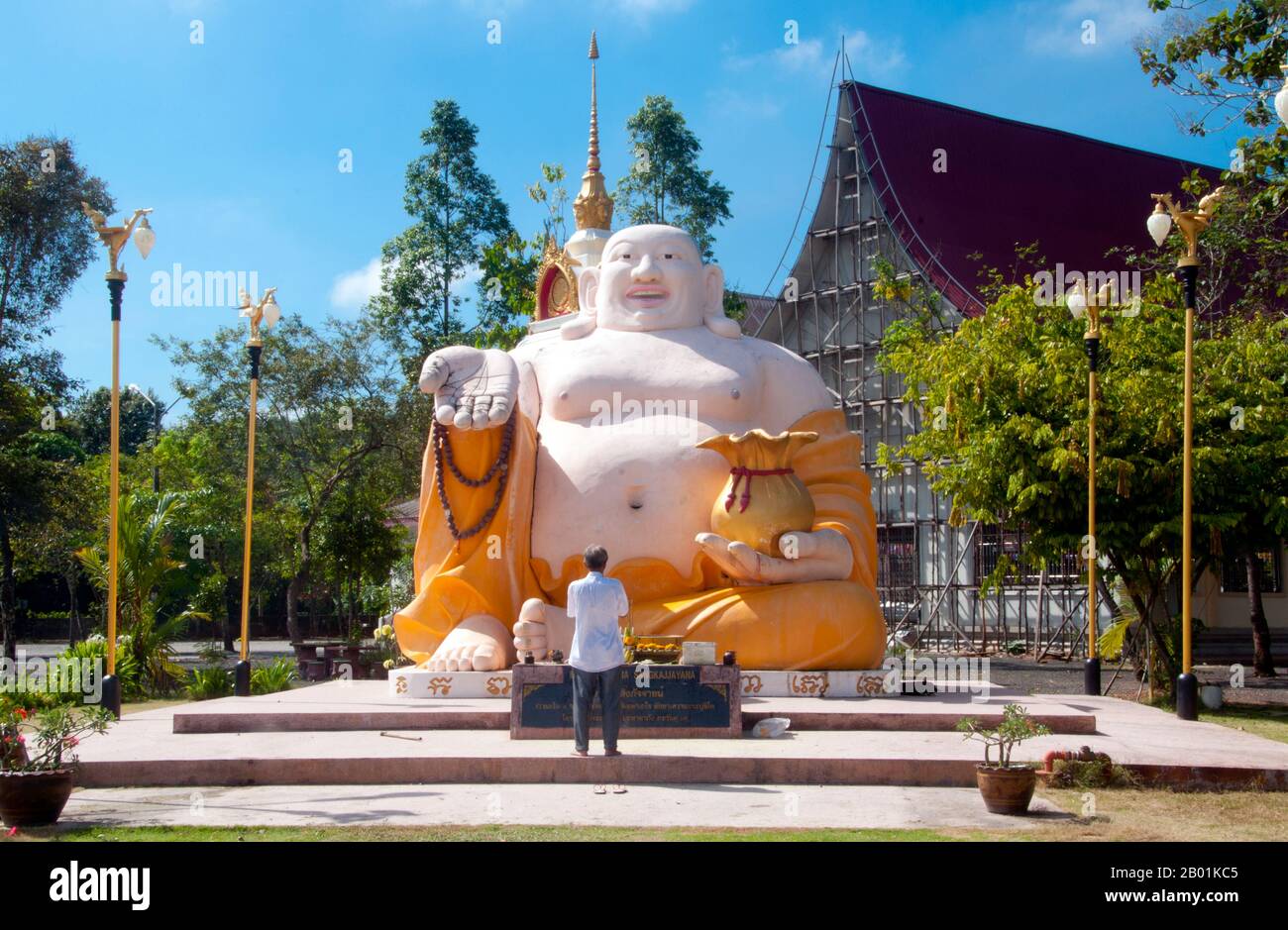 Thailandia: Statua di Phra Sangkajjayana (Buddha che ride o Budai), Wat Matchimaphum, città di Trang, provincia di Trang, Thailandia meridionale. Budai, pronunciato Hotei in giapponese e Bố Đại in vietnamita, è una divinità folcloristica cinese. Il suo nome significa "sacco di stoffa" e deriva dalla borsa che è tradizionalmente raffigurata come portatrice. Di solito è identificato con (o come incarnazione di) Buddha Maitreya, tanto che l'immagine di Budai è una delle forme principali in cui il Buddha Maitreya è raffigurato in Asia orientale. È quasi sempre mostrato sorridere o ridere, da qui il suo soprannome cinese, il Buddha ridendo Foto Stock