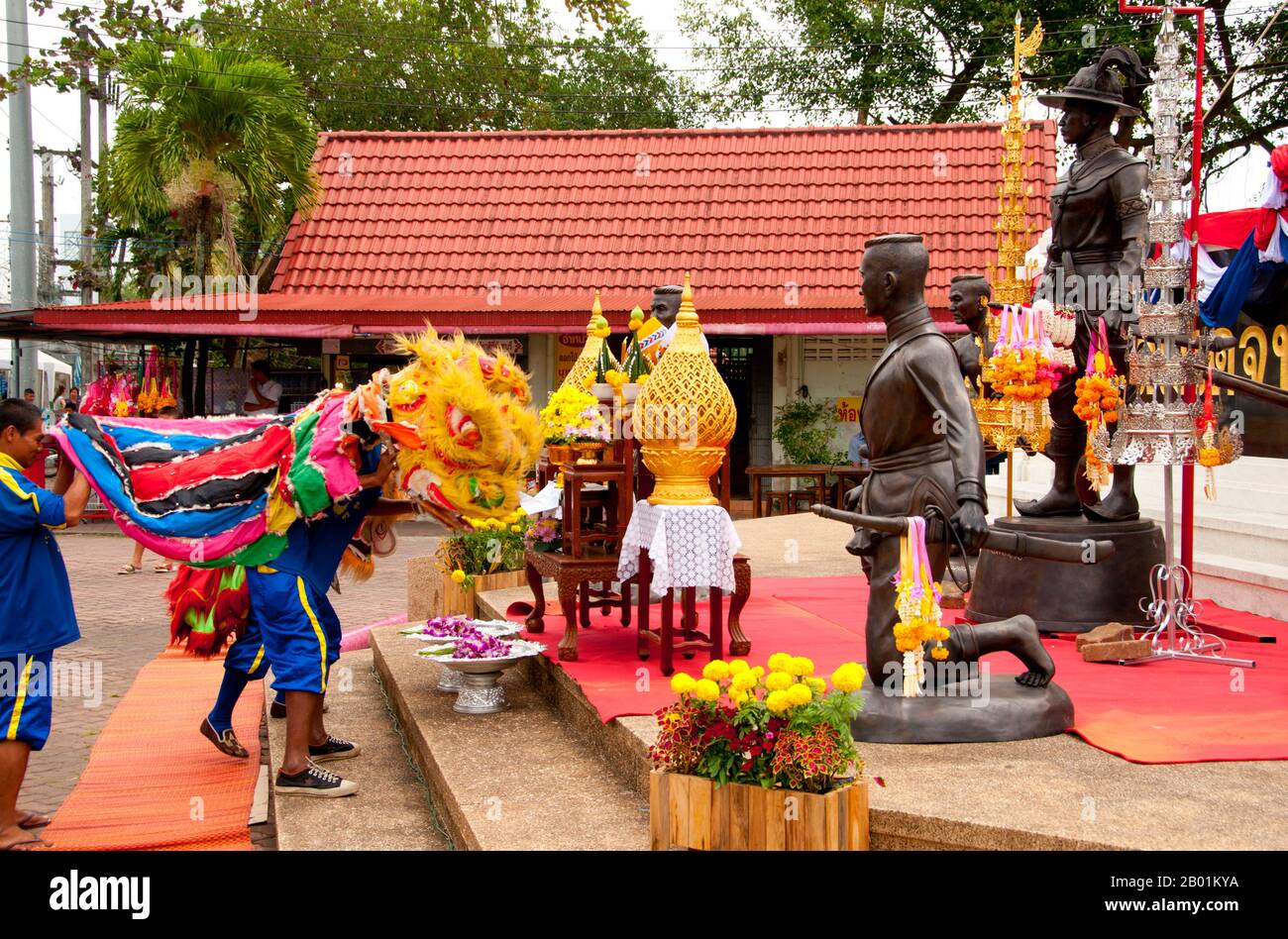 Thailandia: Una danza cinese del leone in onore di re Taksin, statua del re Taksin all'ingresso del parco di re Taksin, Chanthaburi, provincia di Chanthaburi. Chanthaburi è celebrato in tutta la Thailandia per i suoi eroici legami con re Taksin il grande, il conquistatore che combatté contro gli occupanti birmani di Ayutthaya nel 1767 e continuò a ristabilire l'indipendenza thailandese. Anche se Taksin governò solo brevemente dalla sua nuova capitale Thonburi (r. 1768-1782), il suo nome rimane molto venerato, ed è commemorato attraverso Chanthaburi in una serie di santuari, monumenti, parchi e persino un cantiere navale. Foto Stock