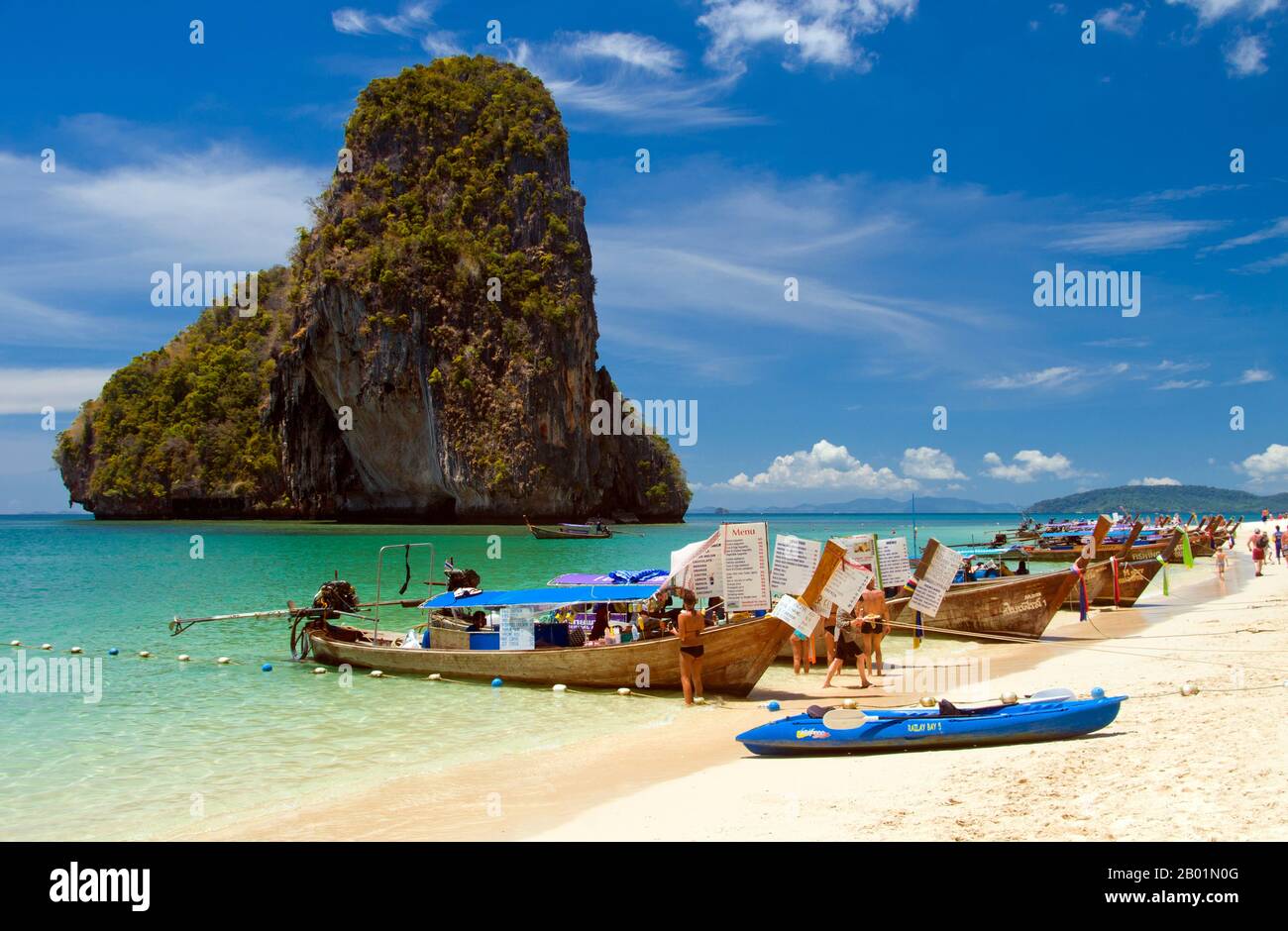 Thailandia: Barche per tour e barche per cibo allineate sulla spiaggia di Hat Tham Phra Nang, costa di Krabi. Hat Tham Phra Nang, la «spiaggia della venerata signora», è una bellissima spiaggia di sabbia bianca situata all'estremità meridionale della piccola penisola che divide Rai le East Beach da Rai Leh West Beach. La spiaggia è considerata da molti la più bella della regione di Krabi e anche una delle più belle della Thailandia meridionale. Composto da una splendida sabbia bianca e cristallina e riparato da alte scogliere calcaree, l'ambientazione da cartolina è impreziosita da affioramenti carsici nitidi e dalla forma strana. Foto Stock