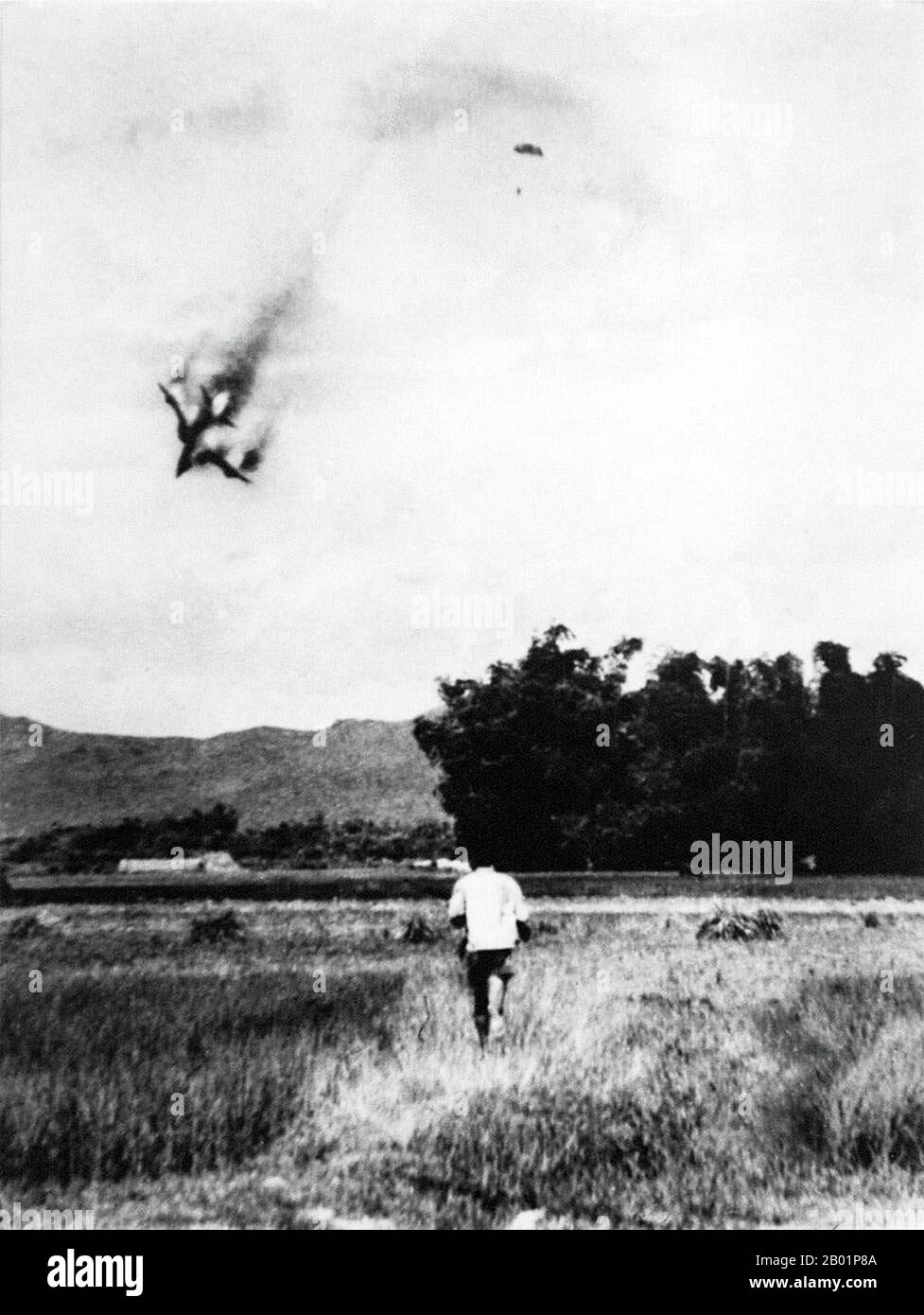 Vietnam: Un aereo da guerra F-105 dell'USAF viene abbattuto vicino a Vinh Phuc, Vietnam del Nord, nel settembre 1966. Il pilota può essere visto paracadutarsi in sicurezza - e in cattività. La seconda guerra d'Indocina, nota in America come guerra del Vietnam, fu un conflitto militare dell'epoca della guerra fredda che si verificò in Vietnam, Laos e Cambogia dal 1 novembre 1955 alla caduta di Saigon il 30 aprile 1975. Questa guerra seguì la prima guerra d'Indocina e fu combattuta tra il Vietnam del Nord, sostenuto dai suoi alleati comunisti, e il governo del Vietnam del Sud, sostenuto dagli Stati Uniti e da altre nazioni anticomuniste. Foto Stock
