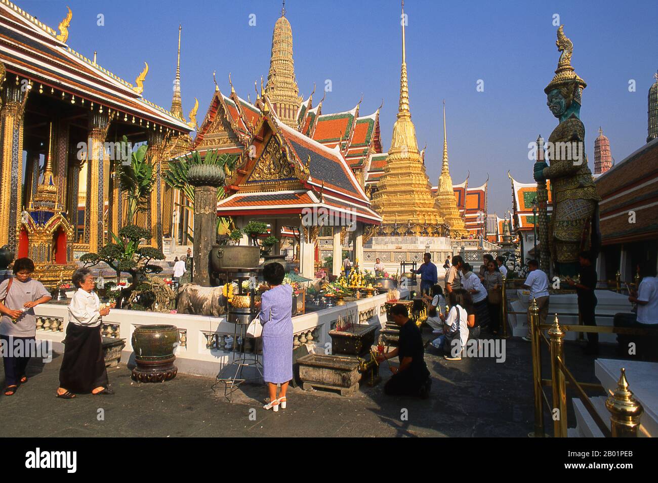 Thailandia: Persone che illuminano incenso al santuario Chao Mae Guan Im (Guanyin) di fronte all'ubosot, Wat Phra Kaew, Bangkok. Wat Phra Kaew (Tempio del Buddha di Smeraldo), nome ufficiale completo Wat Phra si Rattana Satsadaram, è considerato il tempio buddista più sacro della Thailandia. Si trova all'interno dei quartieri del Grand Palace. Il Grand Palace servì come residenza ufficiale dei re di Thailandia dal XVIII secolo in poi. La costruzione del palazzo iniziò nel 1782, durante il regno di re Rama i, quando spostò la capitale attraverso il fiume. Foto Stock