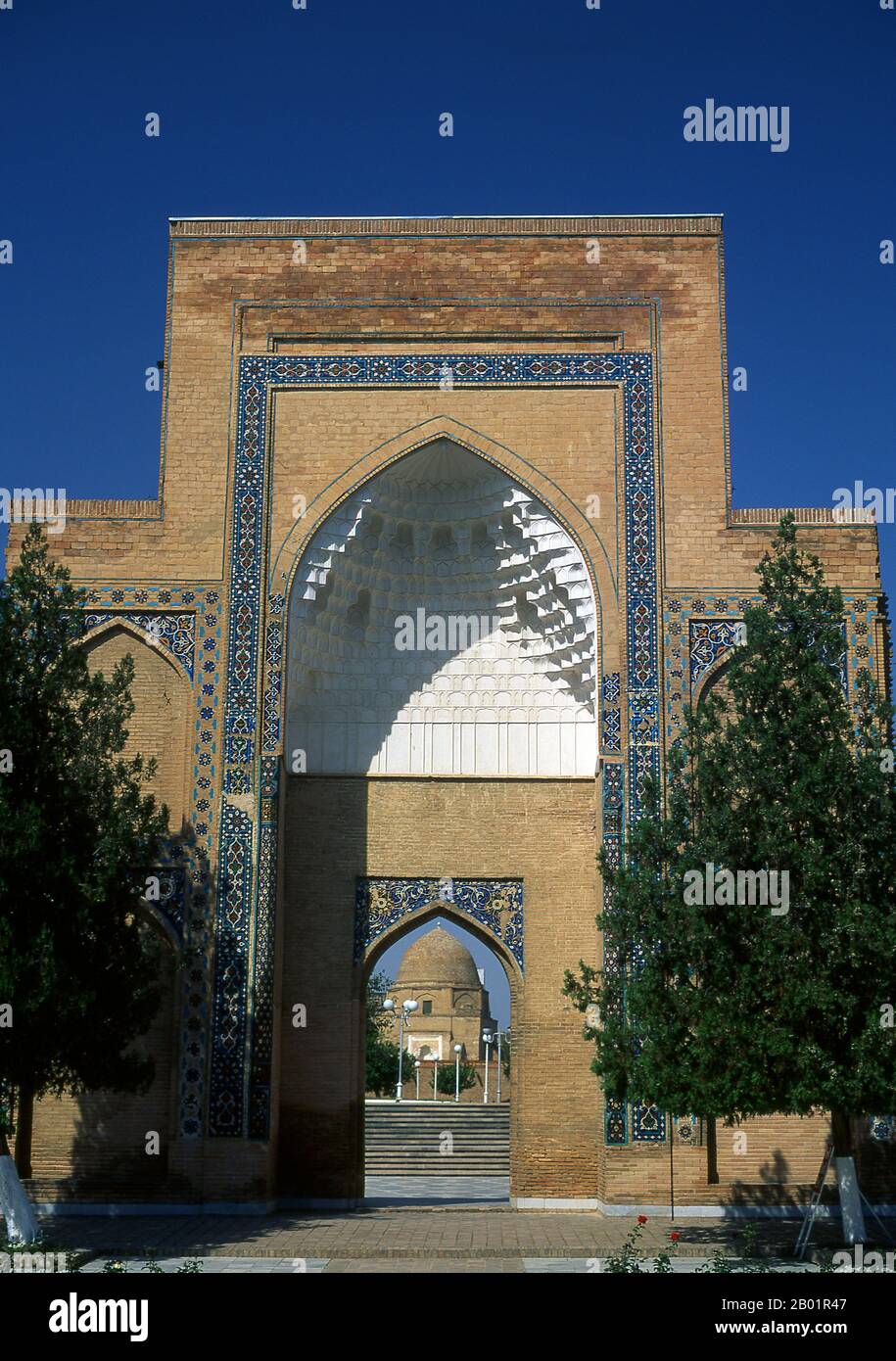 Uzbekistan: Ingresso al Mausoleo Gur-e Amir con il mausoleo sullo sfondo, Samarcanda. Il Gūr-e Amīr o Guri Amir è il mausoleo del conquistatore asiatico Tamerlano (noto anche come Tamerlano) a Samarcanda, Uzbekistan. Gur-e Amir è persiano per "Tomba del Re". Occupa un posto importante nella storia dell'architettura persiana come precursore e modello per le successive grandi tombe dell'architettura moghul, tra cui la tomba di Humayun a Delhi e il Taj Mahal ad Agra, costruito dai discendenti di Tamerlano, la dinastia moghul regnante dell'India settentrionale. E' stato pesantemente restaurato. Foto Stock