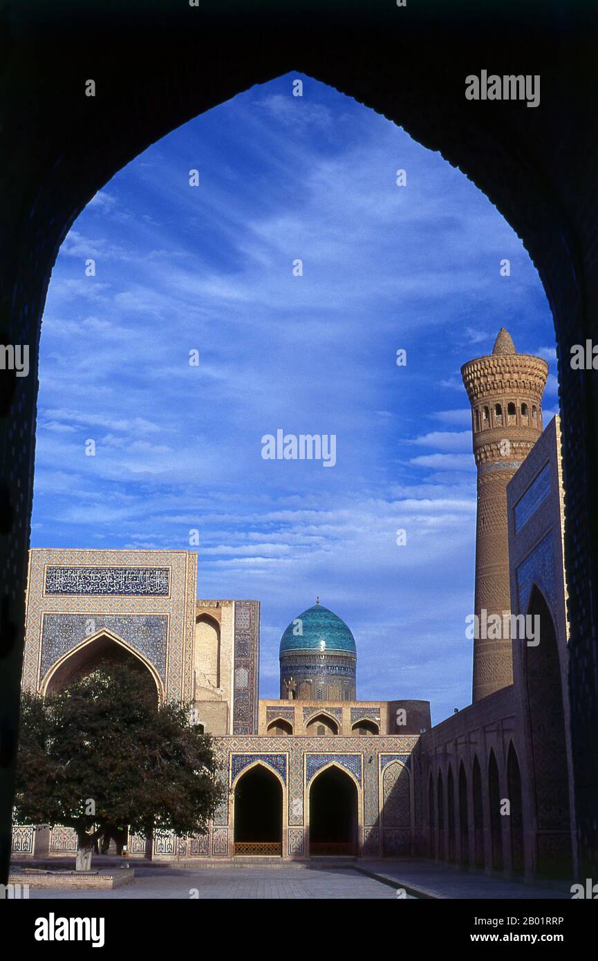 Uzbekistan: Il cortile principale della moschea e minareto Kalyan o Kalon, parte del complesso po-i-Kalyan (sullo sfondo è la cupola della Madrasa Mir-i-Arab), Bukhara. La Moschea Kalyan è la moschea congregazionale di Bukhara o Moschea del venerdì. Fu costruita nel XVI secolo sul sito di una vecchia moschea distrutta da Gengis Khan. Il minareto di Kalyan o Minâra-i Kalân (persiano/tagiko per il "grande minareto") fa parte del complesso della moschea po-i-Kalyan ed è stato progettato da Bako e costruito dal sovrano di Qarakhanide Arslan Khan nel 1127. Foto Stock