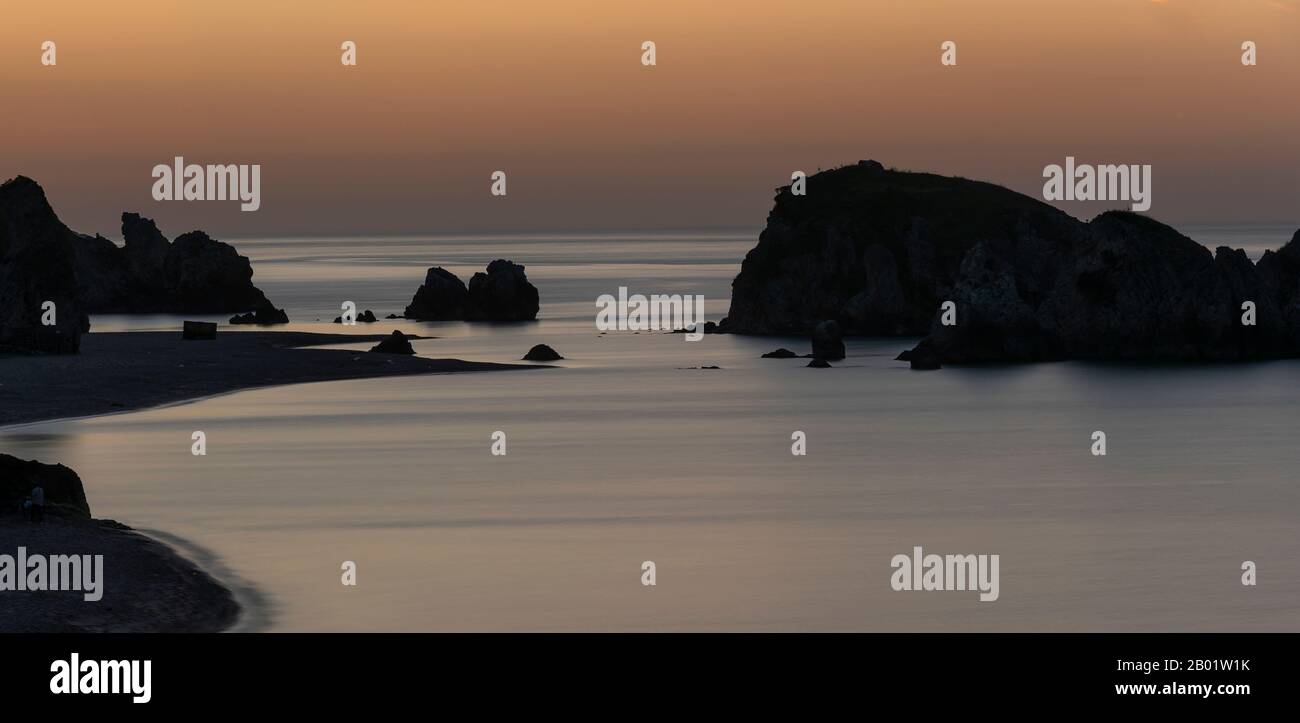 Spiaggia di Imrenli con isole rocciose nel Mar Nero al tramonto con luce dorata e due persone sulla roccia. Foto Stock