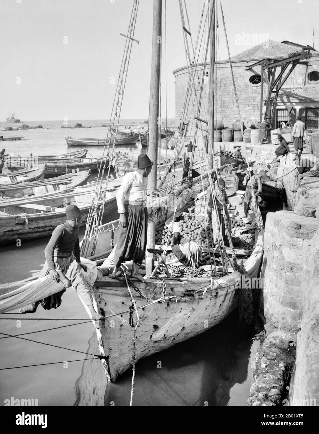 Palestina: Una barca costiera carica di arance da uomini palestinesi a Jaffa, 1910 circa. Palestina è un nome dato alla regione geografica tra il Mar Mediterraneo e il fiume Giordano. La regione è anche conosciuta come la Terra di Israele, la Terra Santa e il Levante meridionale. Nel 1832 la Palestina fu conquistata dall'Egitto di Muhammad Ali, ma nel 1840 la Gran Bretagna intervenne e restituì il controllo del Levante agli ottomani in cambio di ulteriori capitolazioni. La fine del XIX secolo vide l'inizio dell'immigrazione sionista e la rinascita della lingua ebraica. Foto Stock