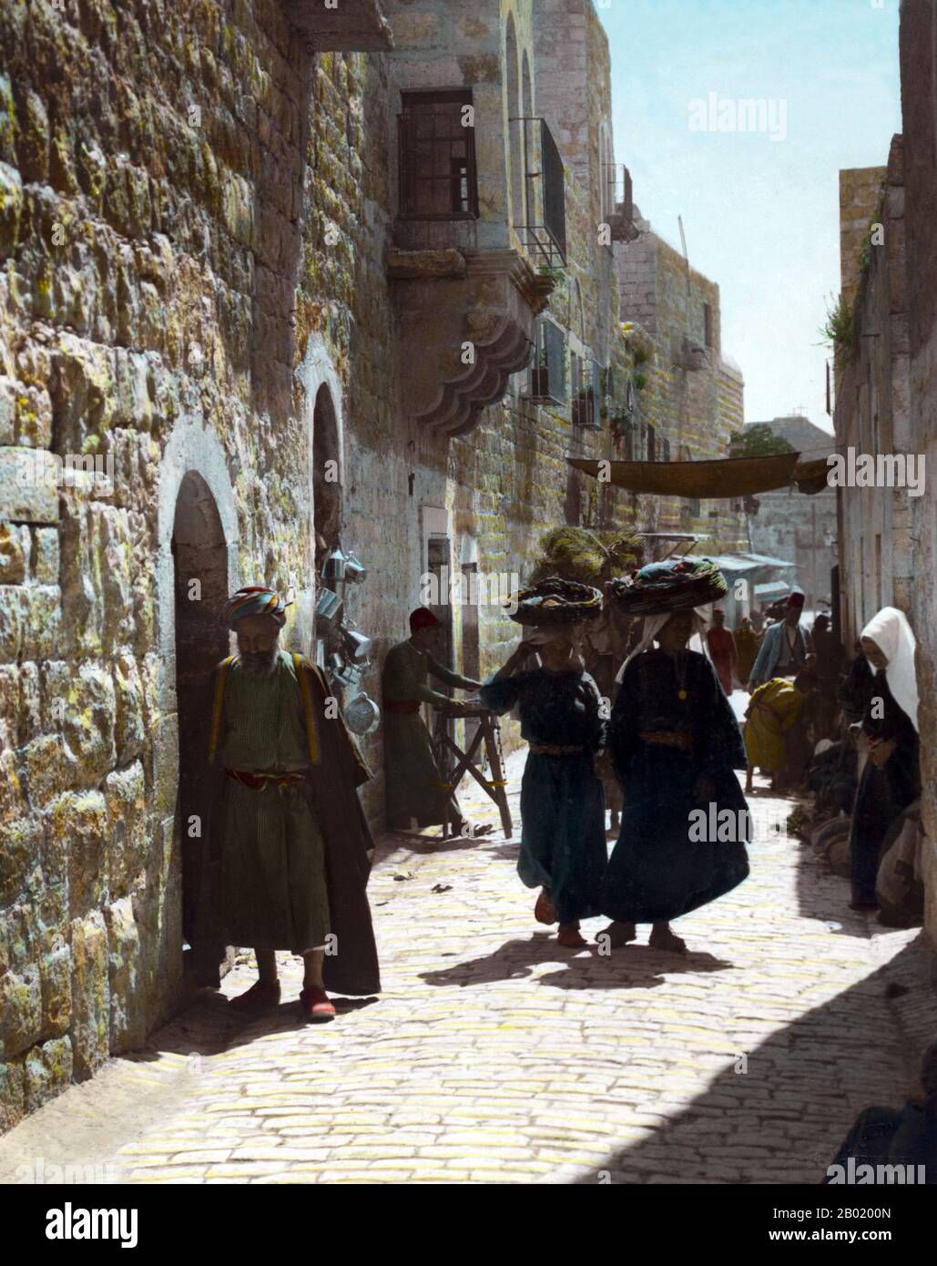 Palestina: Palestinesi nella strada che conduce alla Chiesa della Natività a Betlemme, 1898-1919. Palestina è un nome dato alla regione geografica tra il Mar Mediterraneo e il fiume Giordano. La regione è anche conosciuta come la Terra di Israele (Eretz-Yisra'el), la Terra Santa e il Levante meridionale. Nel 1832 la Palestina fu conquistata dall'Egitto di Muhammad Ali, ma nel 1840 la Gran Bretagna intervenne e restituì il controllo del Levante agli ottomani in cambio di ulteriori capitolazioni. La fine del XIX secolo vide l'inizio dell'immigrazione sionista e la rinascita della lingua ebraica. Foto Stock