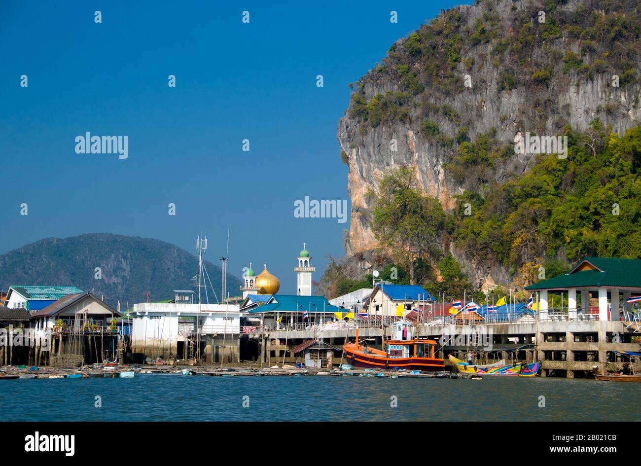 Thailandia: Villaggio di pescatori musulmani di Panyi, Parco Nazionale di Ao Phang Nga (Baia di Phangnga), Provincia di Phang Nga. Ko Panyi è un enorme affioramento carsico nel lee di cui un prospero villaggio di pescatori musulmano tailandese si rifugia dal Monsone Sud-Ovest. L'insolita ubicazione del villaggio di pescatori musulmano palafittato, insieme alla moschea e al minareto inaspettati, ha fornito agli abitanti di Ko Panyi una fonte di reddito supplementare inaspettata e gradita negli anni dall'avvento del turismo. Anche se l'isola è diventata commercializzata, la gente è notevolmente aperta e amichevole. Foto Stock