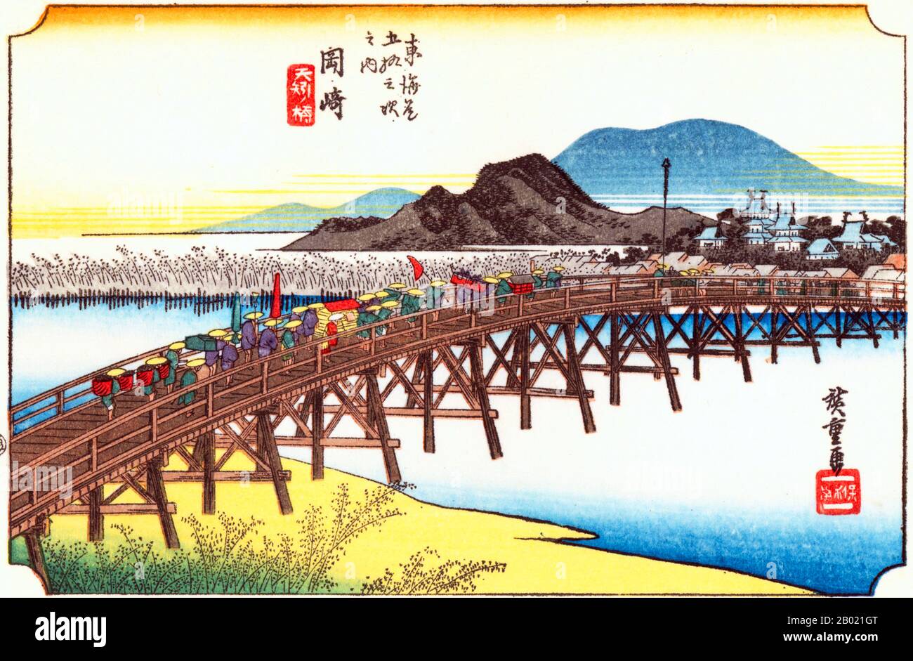 Okazaki: Cortège di un daimyo che attraversa il ponte sul fiume Yahagi verso il villaggio e il castello sulla riva successiva; sullo sfondo una collina blu, stampata solo da blocchi di colore. Tokugawa Ieyasu, il fondatore dello Shogunate Tokugawa, è nato nel castello mostrato nelle stampe. Il ponte sul fiume Yahagi, che scorre a ovest del castello, era il più grande su tutta l'autostrada. Utagawa Hiroshige (歌川 広重, 1797 – 12 ottobre 1858) è stato un . Fu anche chiamato Andō Hiroshige (安藤 広重) (una combinazione irregolare Foto Stock