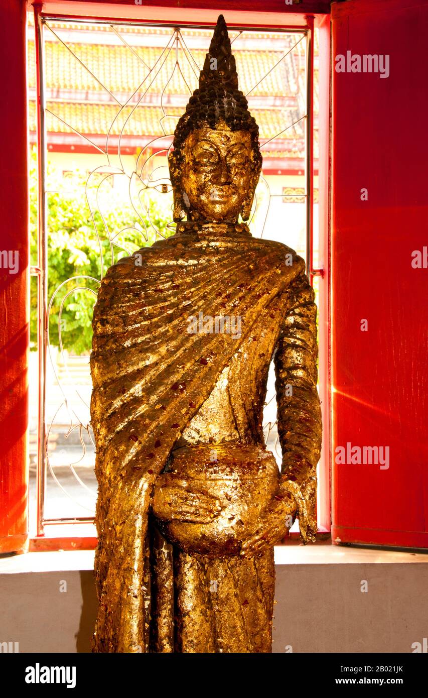 Thailandia: Buddha in piedi nel viharn principale, Wat Phra Thong, Phuket. Il tempio buddista di Wat Phra Thong, il «Tempio del Buddha d'oro», si trova nel distretto Thalang dell'isola di Phuket. Questo insolito tempio prende il nome dall'immagine dorata (o dorata) del Buddha che è sepolta all'interno del recinto del tempio in modo che solo la testa e le spalle siano visibili sopra il suolo. Secondo la leggenda, un ragazzo di bufalo locale tentò di legare una delle sue accuse a un affioramento che pensava fosse un ceppo d'albero, ma che si rivelò essere l'ushnisha o il nodo superiore di un'immagine sepolta del Buddha. Foto Stock