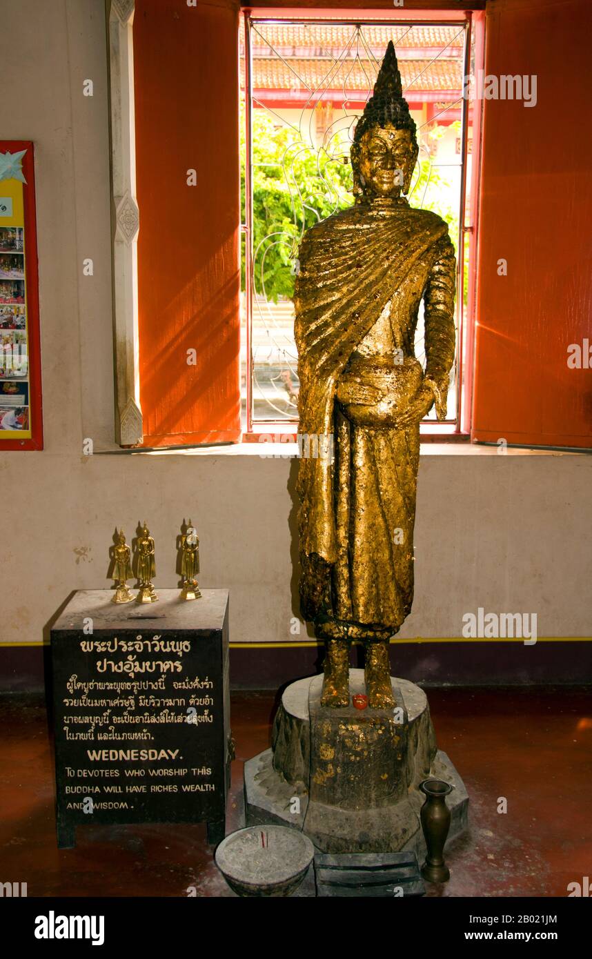 Thailandia: Buddha in piedi nel viharn principale, Wat Phra Thong, Phuket. Il tempio buddista di Wat Phra Thong, il «Tempio del Buddha d'oro», si trova nel distretto Thalang dell'isola di Phuket. Questo insolito tempio prende il nome dall'immagine dorata (o dorata) del Buddha che è sepolta all'interno del recinto del tempio in modo che solo la testa e le spalle siano visibili sopra il suolo. Secondo la leggenda, un ragazzo di bufalo locale tentò di legare una delle sue accuse a un affioramento che pensava fosse un ceppo d'albero, ma che si rivelò essere l'ushnisha o il nodo superiore di un'immagine sepolta del Buddha. Foto Stock