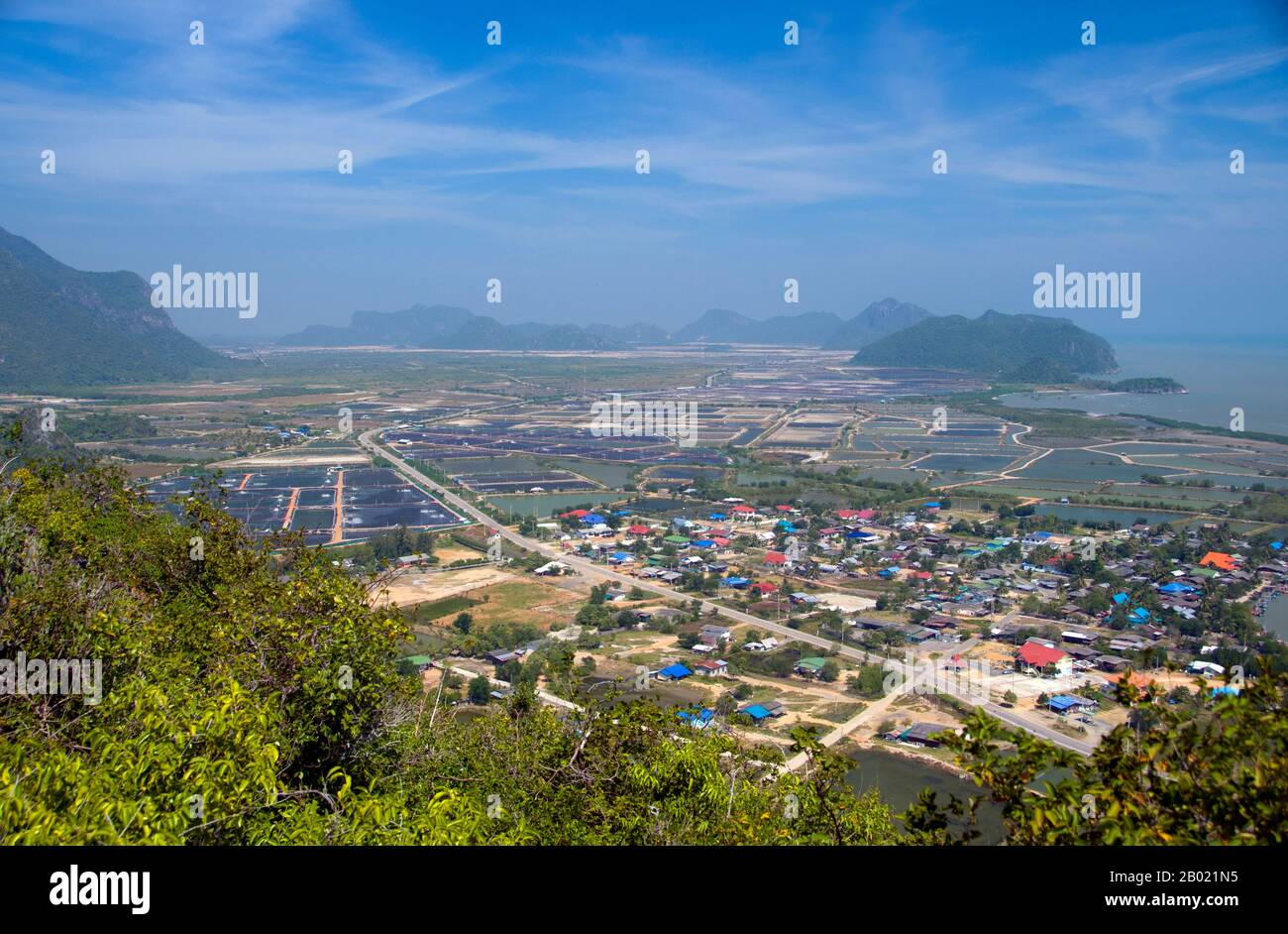 Thailandia: Vista di Ban Khao Daeng e della campagna circostante dal punto panoramico di Khao Daeng, Parco Nazionale di Khao Sam ROI Yot, Provincia di Prachuap Khiri Khan. Khao Sam ROI Yot è diventato il primo parco nazionale costiero della Thailandia nel 1996. Copre un'area di circa 100 chilometri quadrati (40 miglia quadrate) tra cui ripide montagne calcaree disseminate di grotte, paludi, paludi di mangrovie, spiagge sabbiose e acque marine poco profonde lungo la costa. Il nome sam roi yot significa “trecento picchi” e questo si riferisce direttamente ai numerosi affioramenti e picchi calcarei che caratterizzano il parco. Foto Stock