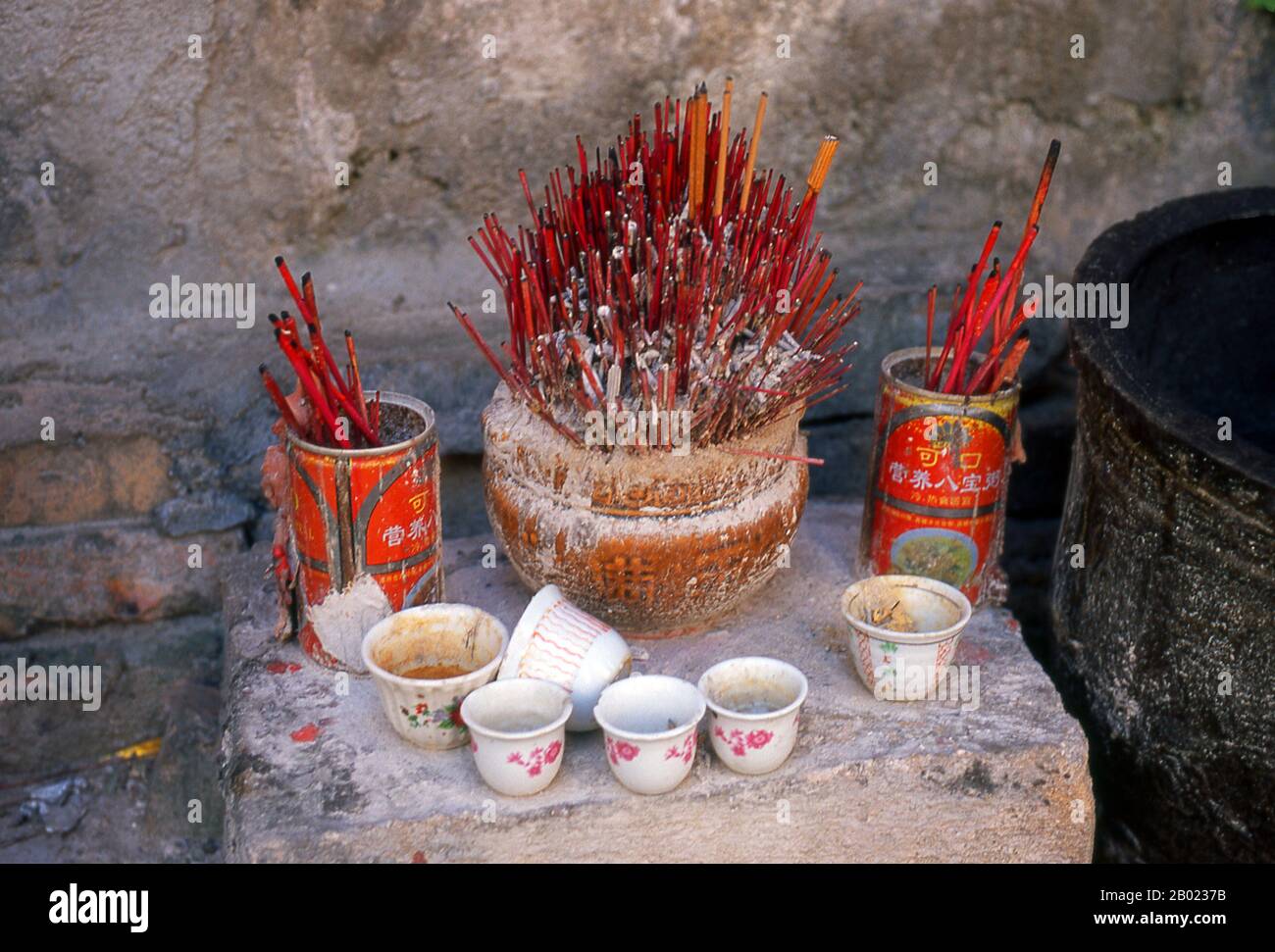 Cina: Santuario di strada con supporti di incenso accanto a un vecchio negozio degli anni '1920, Zhongshan Lu, Beihai, provincia del Guangxi. Il porto di Beihai sulla costa meridionale della Cina, nella provincia del Guangxi, ospita ancora edifici in stile europeo del XIX secolo che ricordano la sua storia come porto trattato (i migliori esempi sono vicino al lungomare); la città è anche conosciuta per le sue spiagge. Dopo il trattato sino-britannico di Yantai del 1876, otto nazioni occidentali (Regno Unito, Stati Uniti, Germania, Austria-Ungheria, Francia, Italia, Portogallo e Belgio) istituirono ambasciate, ospedali, chiese, scuole e costumi marittimi. Foto Stock