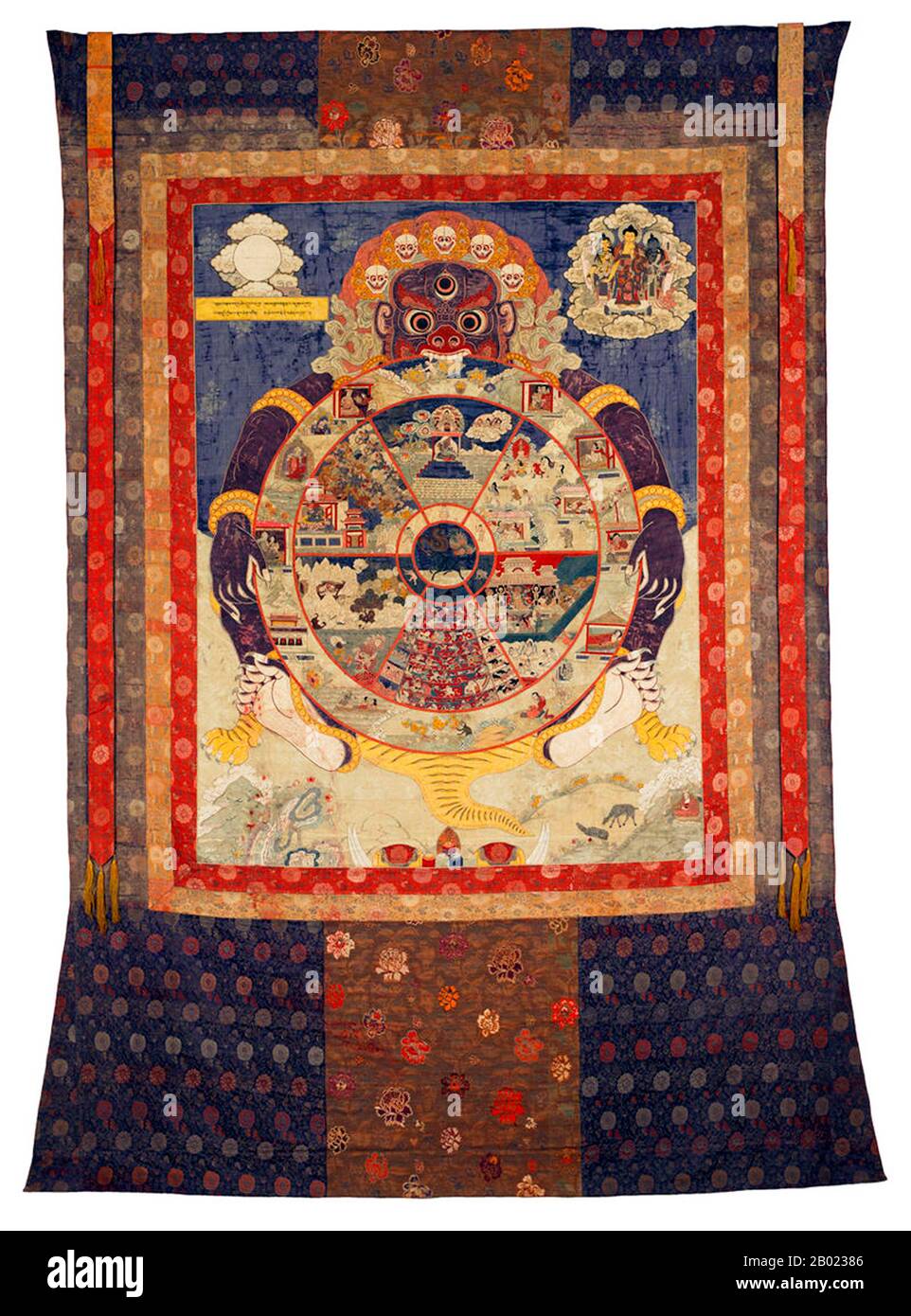 Cina/Tibet: Thangka/thanka che rappresenta la morte (Marana) consumando i piani dell'esistenza samarica (ruota dell'esistenza). Ricamo di seta, c. 1800. Jarāmaraṇa è sanscrito e Pāli per "vecchiaia" (jarā) e "morte" (maraṇa). Nel buddismo, il jaramarana si riferisce all'inevitabile sofferenza alla fine della vita di tutti gli esseri prima della loro rinascita nel ciclo di saṃsāra. Foto Stock